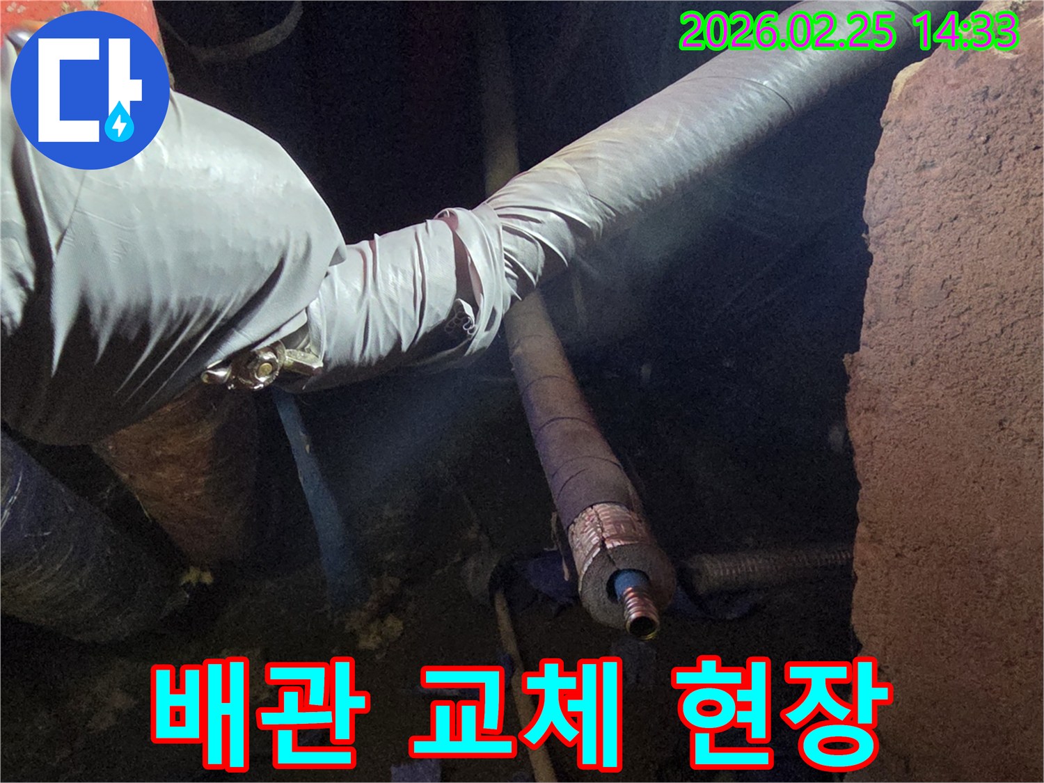 어두운 작업 공간에서-장갑을 낀 손이-손상된 배관을-새로운 배관으로-안전하게 교체하기 위해-준비하는 모습입니다