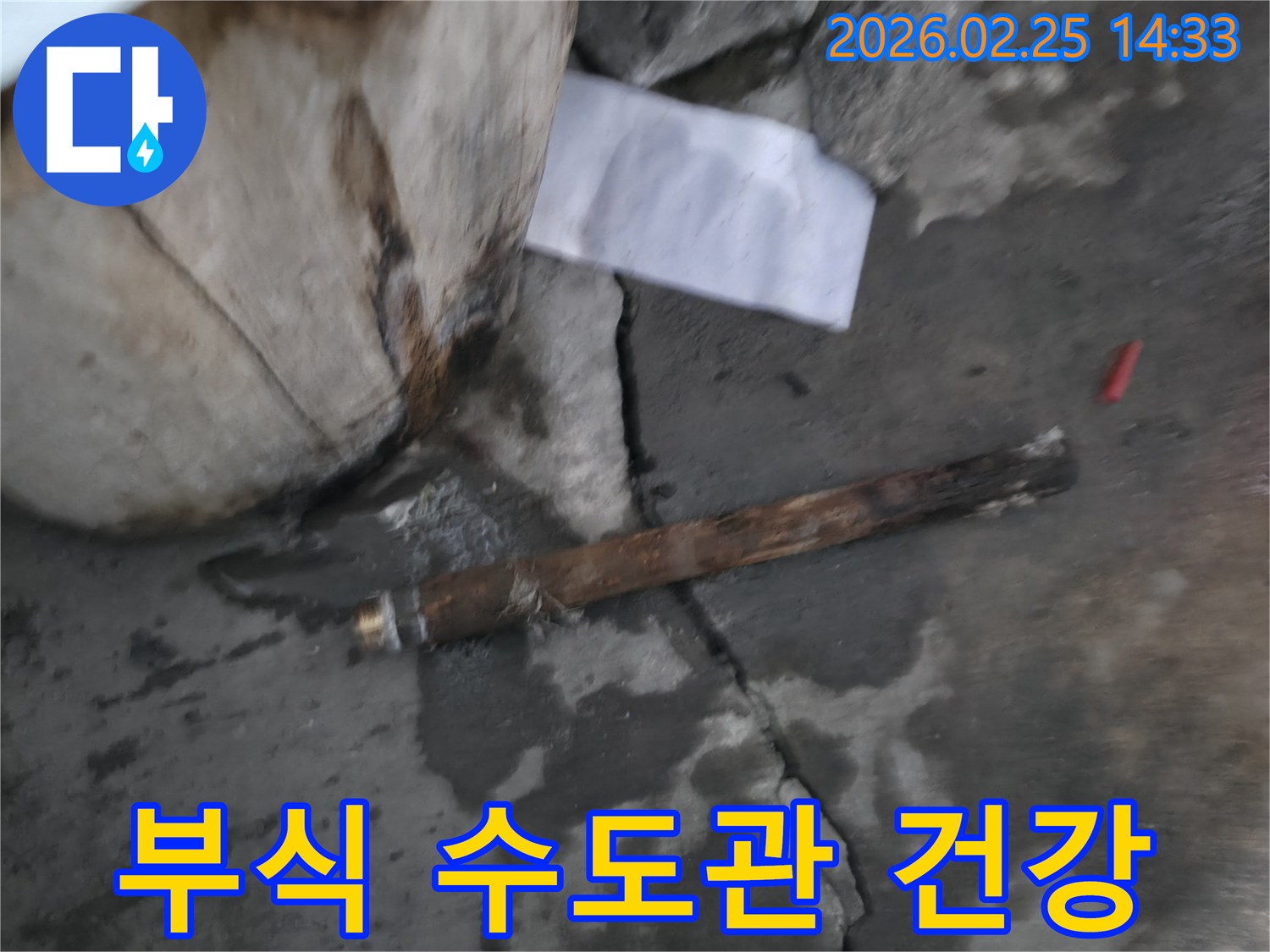 오래되어 부식된-파열된 수도관이-젖은 바닥에 놓여있는-누수 공사 현장 사진입니다.