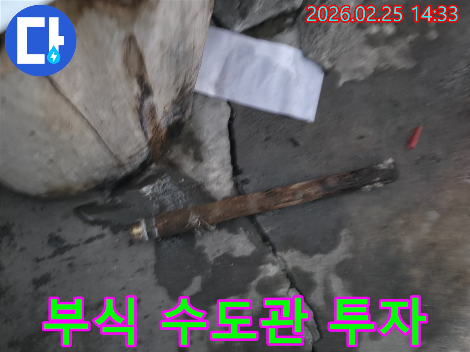 오래되어 부식된-파열된 수도관이-젖은 바닥에 놓여있는-누수 공사 현장 사진입니다.