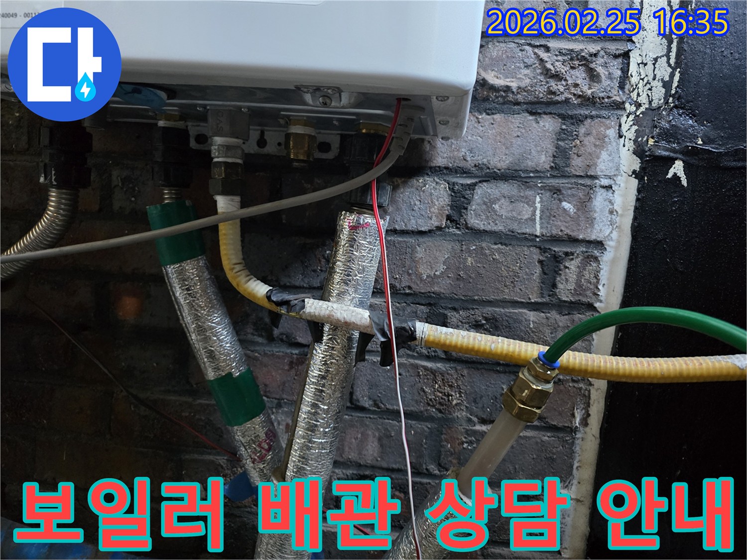 이 이미지는-벽에 설치된-보일러 하단부의-복잡한 배관 연결부와-전선-그리고-은색 단열재로-감싸진-파이프들을-보여주며-누수 문제에 대한-친절한 상담이-필요함을-암시합니다.