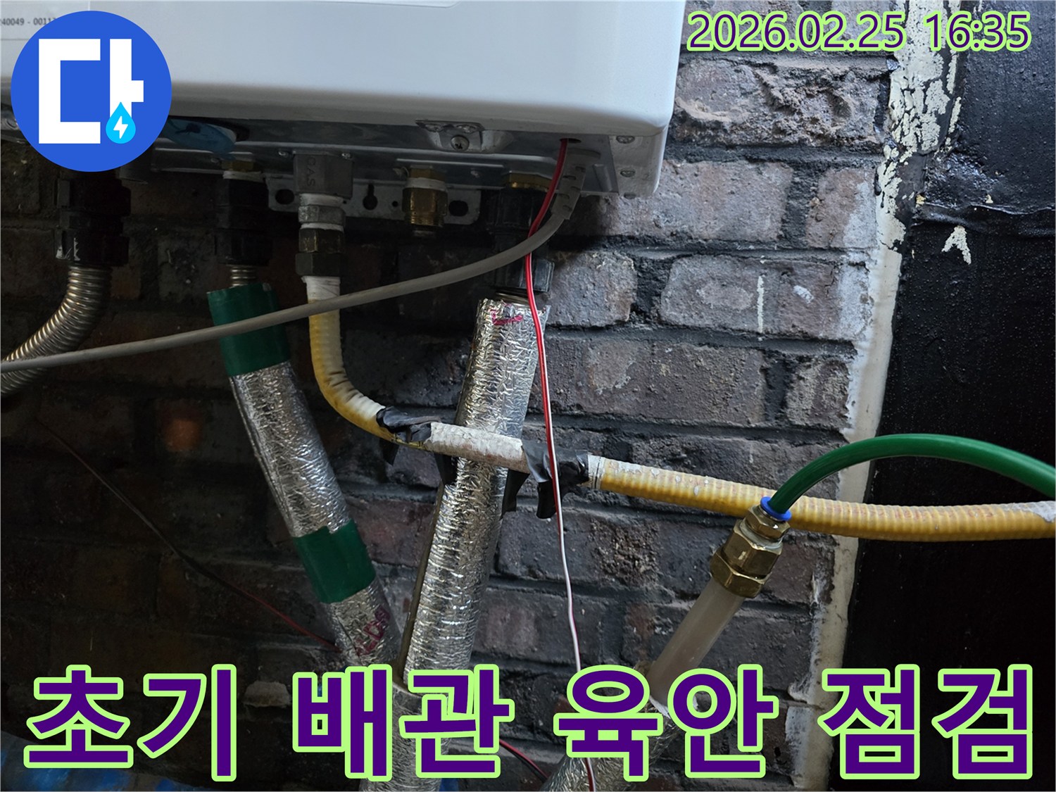 이 이미지는-보일러 하단부의-다양한 배관과-전선-단열재가-복잡하게-얽혀있는-모습을-보여주며-누수 문제의-초기 육안 점검이-진행되고-있음을-나타냅니다.