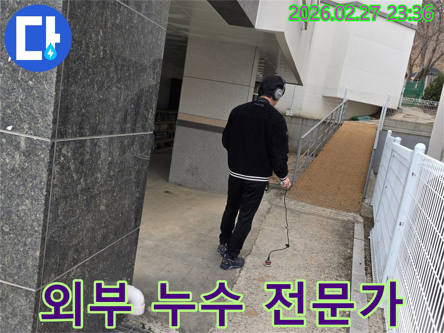 누수 엔지니어가-청음식 탐지 장비로-건물 외부의-찾기 어려운 누수 지점을-전문적으로 탐지하는 모습