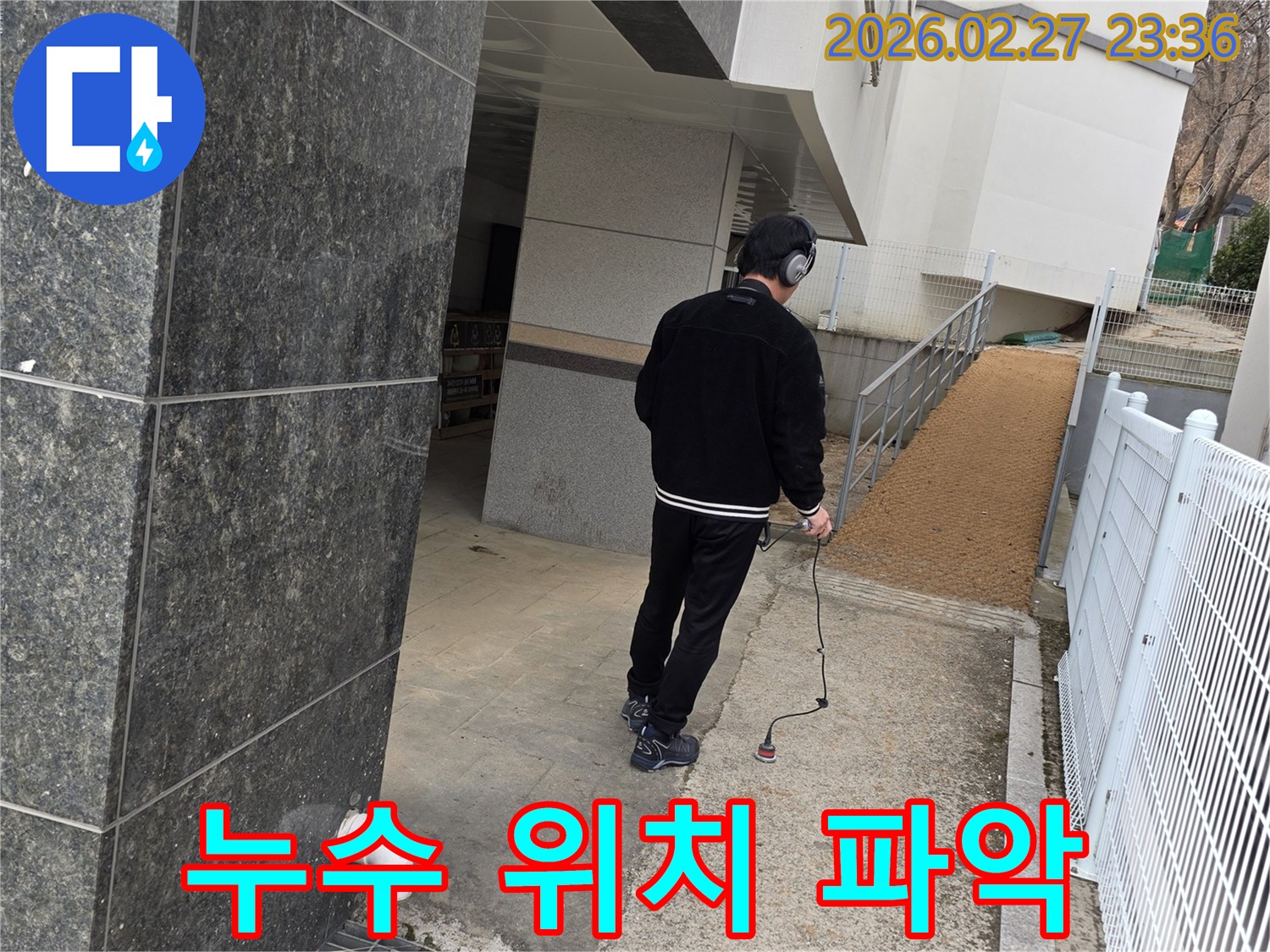 누수 엔지니어가-청음식 탐지기로-건물 외부에서-누수 위치를 정확하게 파악하여-신속한 해결을 돕는 모습