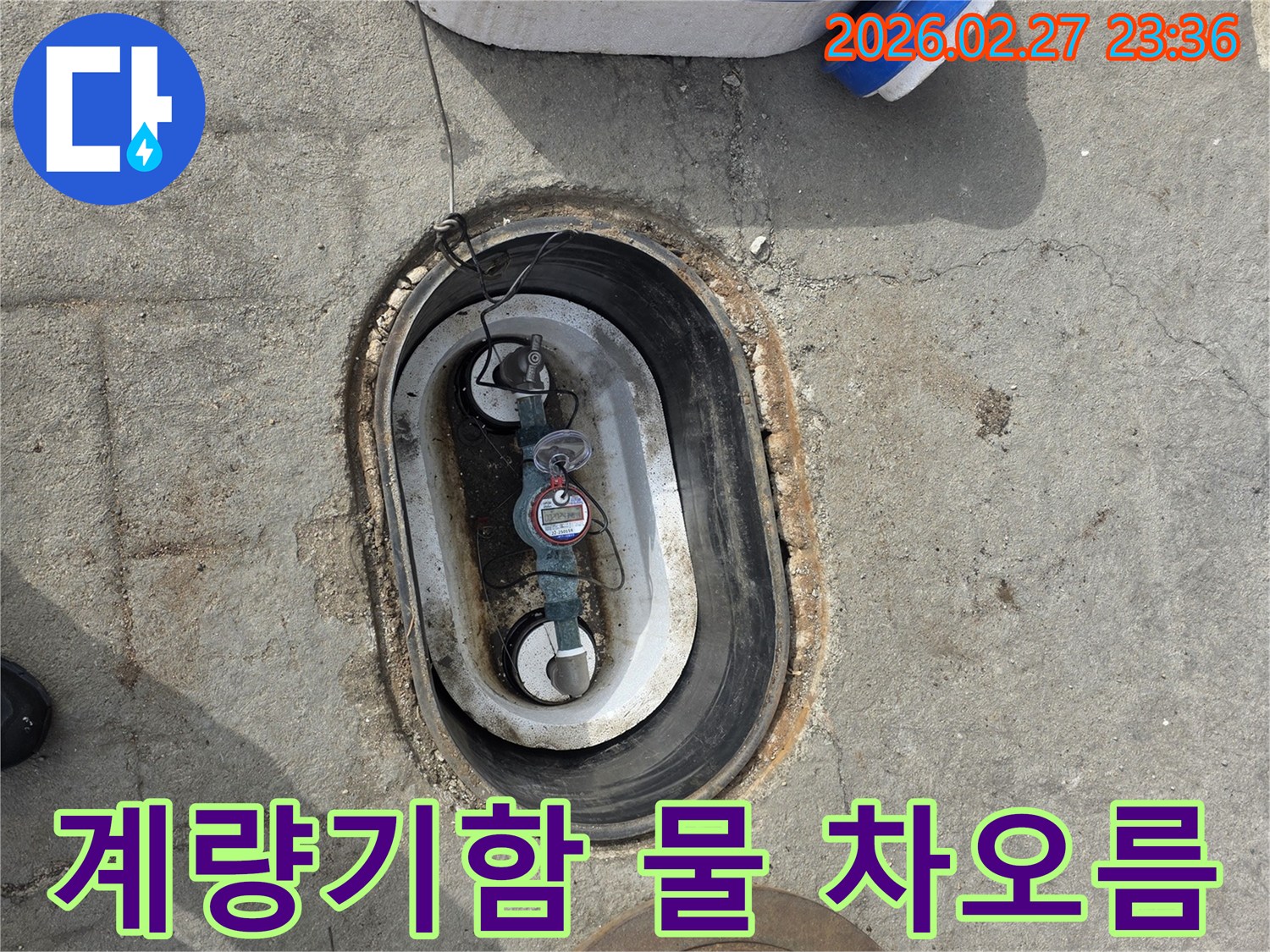 지하에 매설된 수도 계량기함 내부에-물이 차오른 상태를 보여주는 사진입니다.