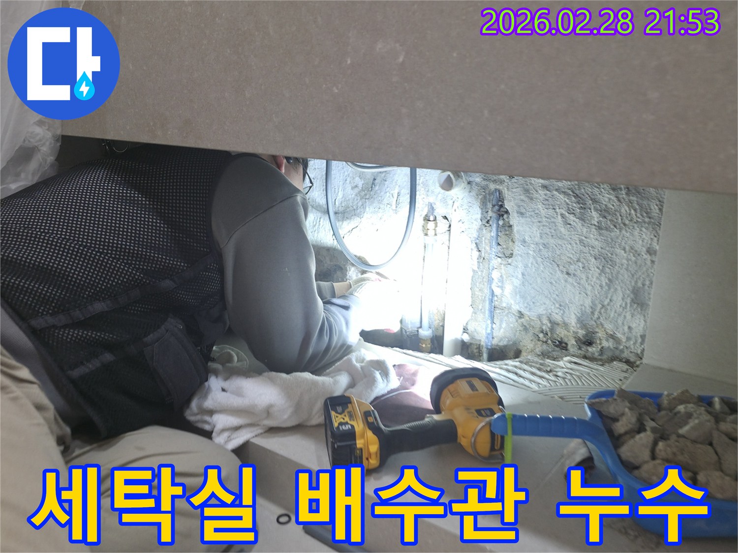 세탁실 배수관의-좁은 틈새에서-누수 지점을-찾기 위해-집중하여-작업하는-전문 엔지니어의 모습입니다.