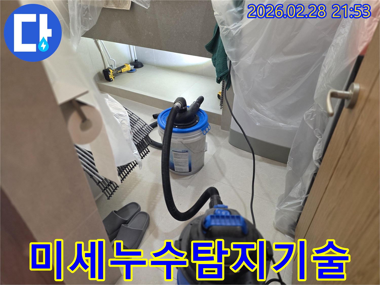 이 이미지는 누수 탐지 작업 시-어두운 공간을 밝히는 조명과-물기를 제거하는 습식 청소 장비를 사용하여-미세한 누수까지 찾아내는 현장을 보여줍니다.