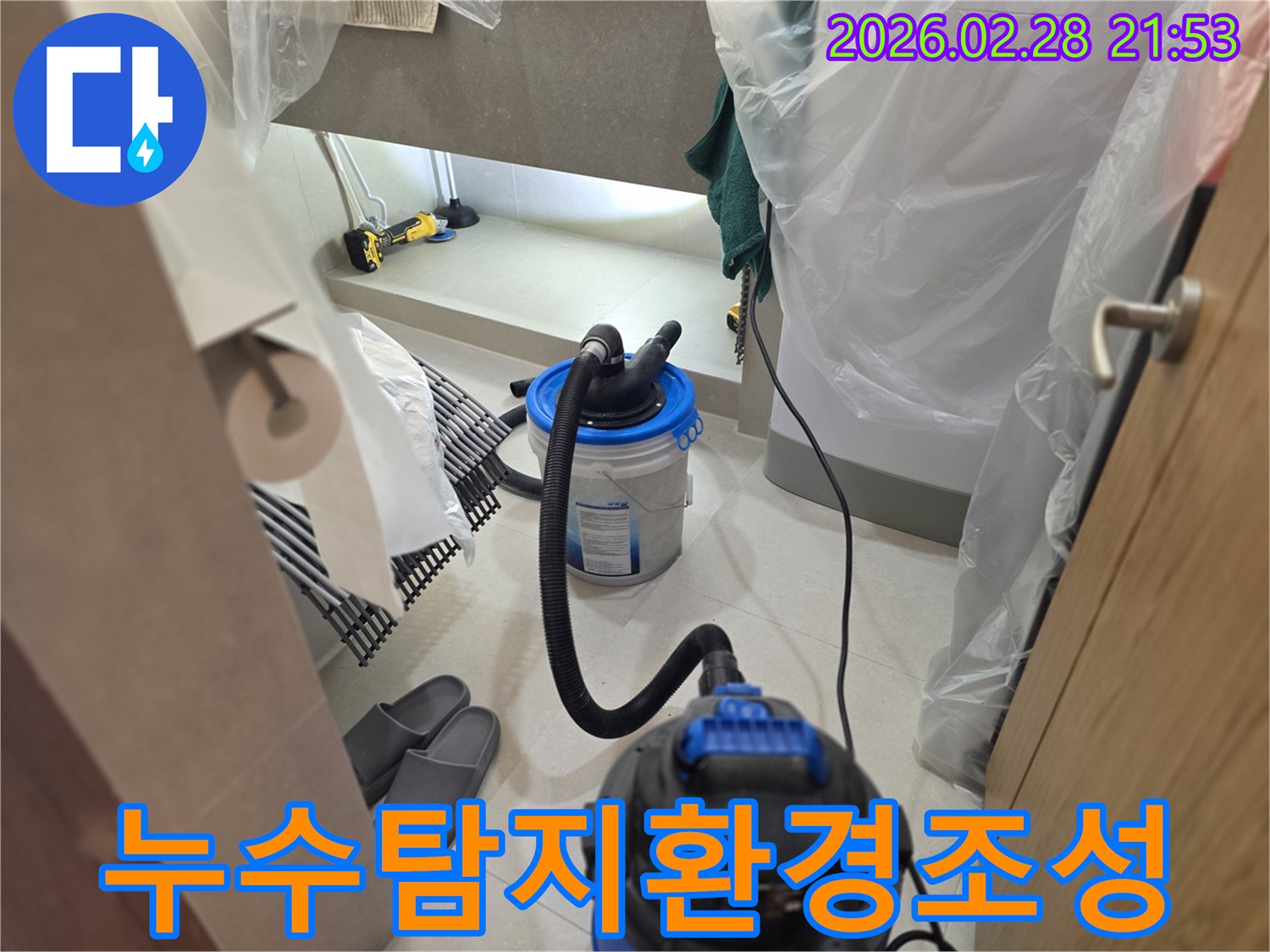 이 이미지는 누수 탐지 작업을 위해-주변을 비닐로 보양하고-습식 청소기와 조명 장비를 설치하여-정확한 진단을 위한 최적의 환경을 조성하는 모습을 보여줍니다.