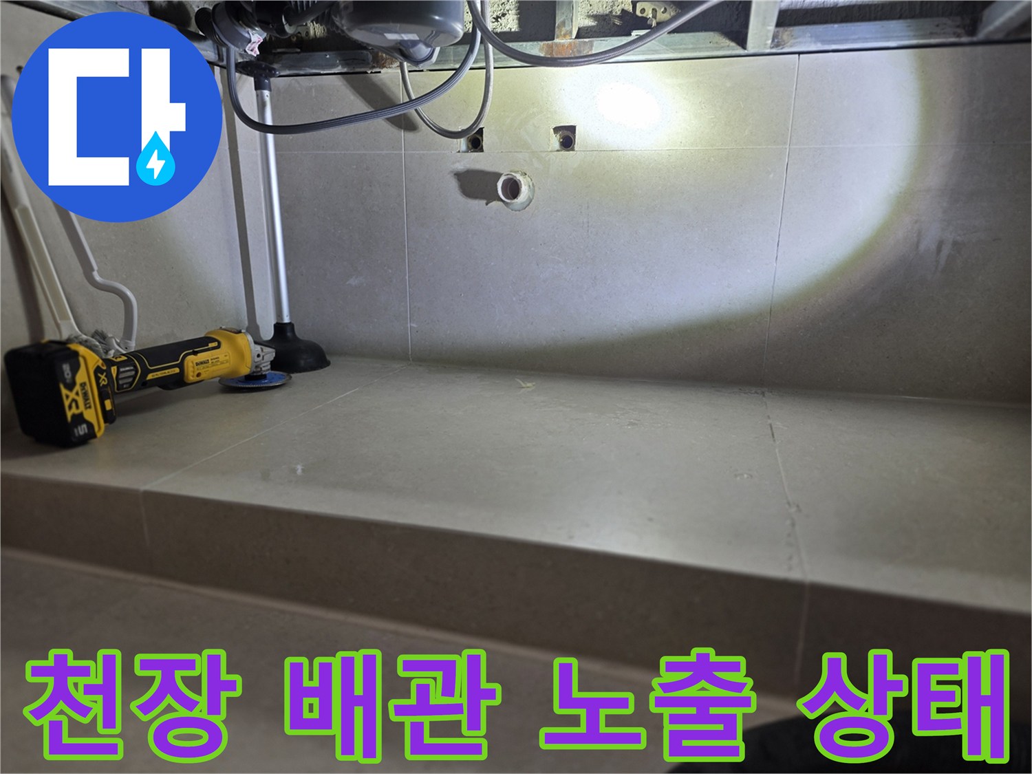 화장실 천장 내부-노출된 배관과 전동드릴 작업 모습