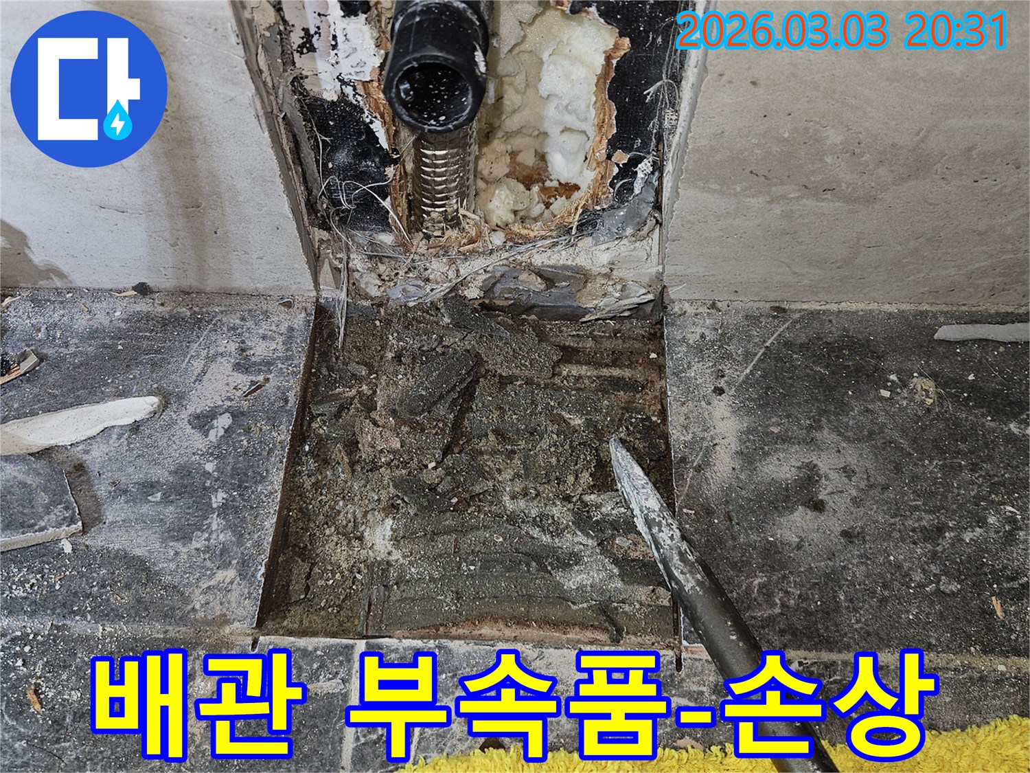 빌라 욕실 타일 뒤에 숨겨진 배관 부속품의 손상으로 인한 누수-현장을 보여주며-정확한 원인 파악의 중요성을 강조합니다.