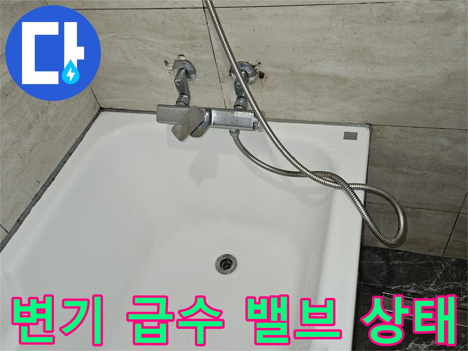 욕조 옆 벽면에 설치된 금속 재질의 급수 부속과 호스
