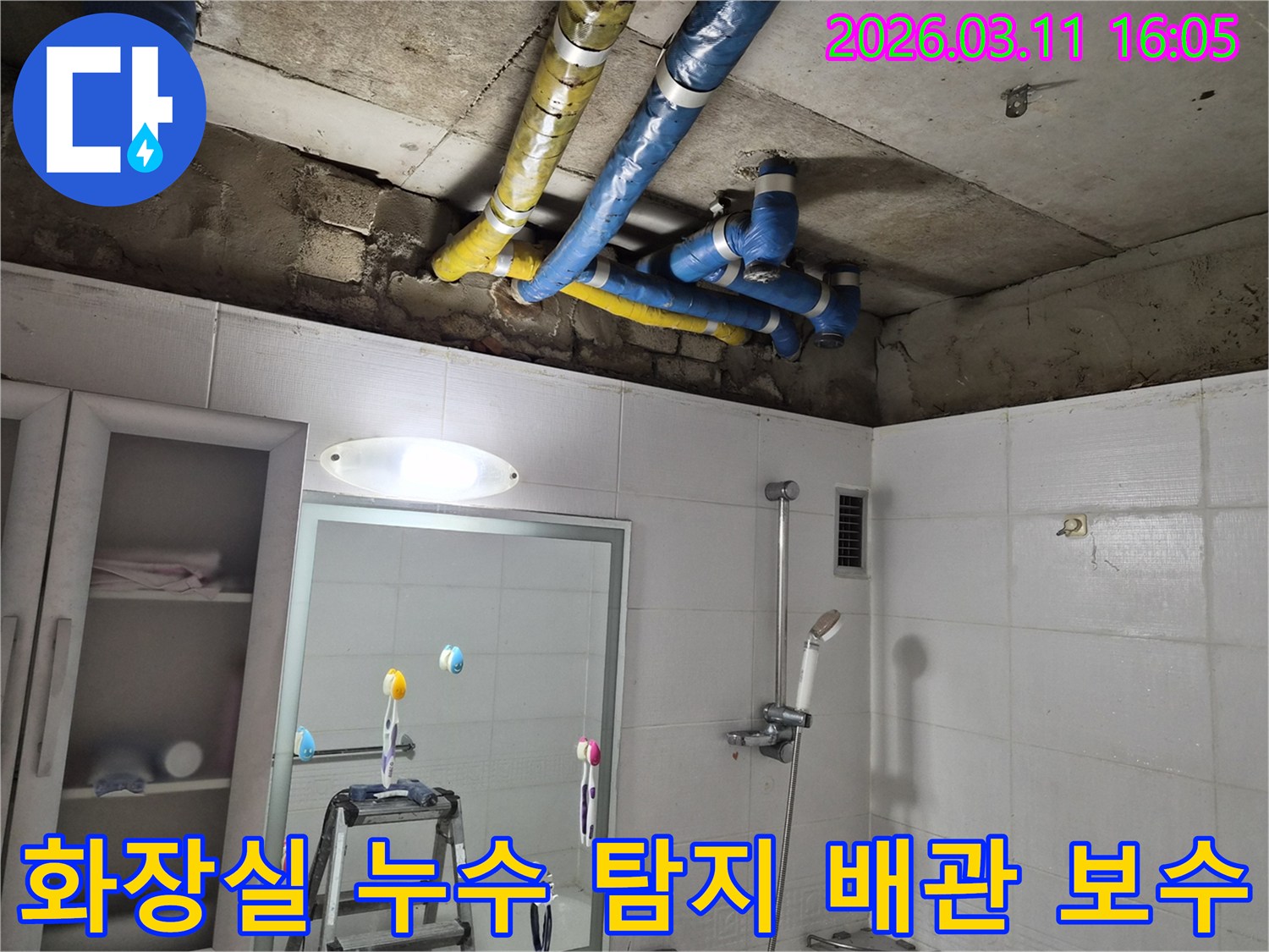 노원구 공릉동 화장실의-천장 배관 누수 현장에서-파란색과 노란색으로-단열된 배관이-수리 완료된 모습입니다.