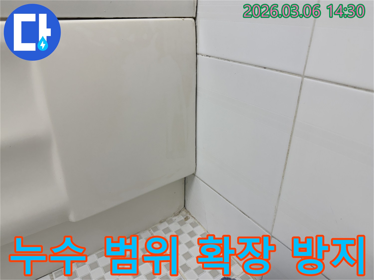 욕실-벽면-하단부의-누수-흔적을-확인한-후-더-이상의-피해-확산을-막기-위한-긴급-조치를-논의하는-모습을-담은-이미지