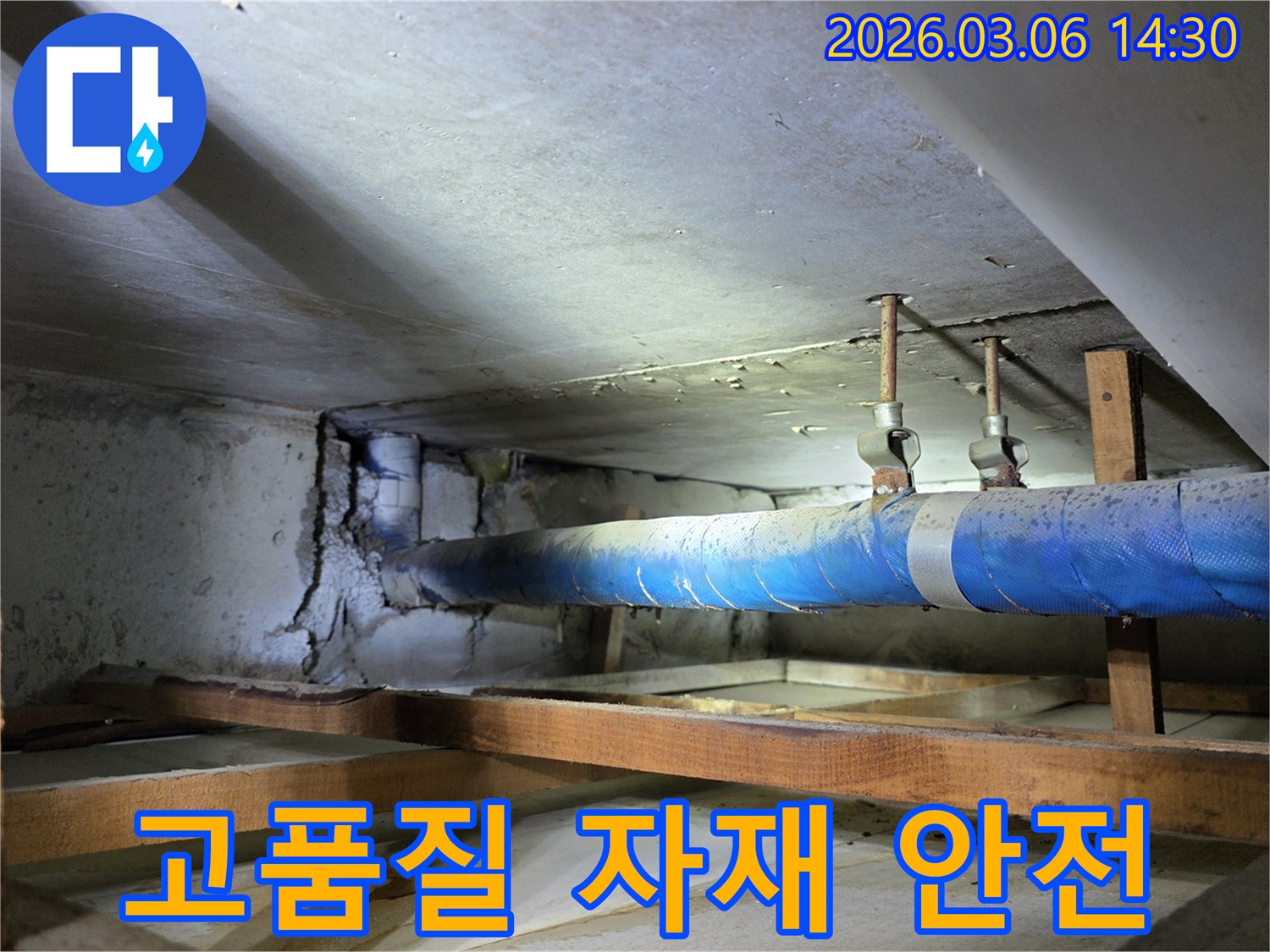 지하 공간의 파란색 배관과-손상된 콘크리트 벽면을-누수 엔지니어가-고품질 자재를 사용하여-안전하게 시공할 계획을-설명하는 모습