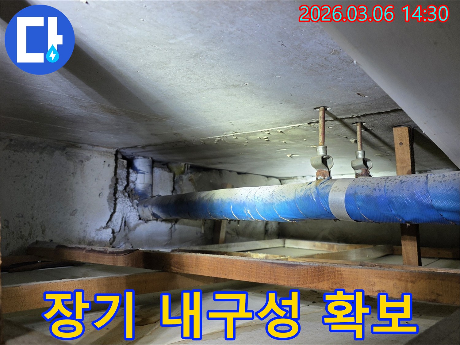 지하 공간의 파란색 배관과-손상된 콘크리트 벽면을-누수 엔지니어가-장기적인 내구성 확보를 위한-해결 방안을 모색하는 모습