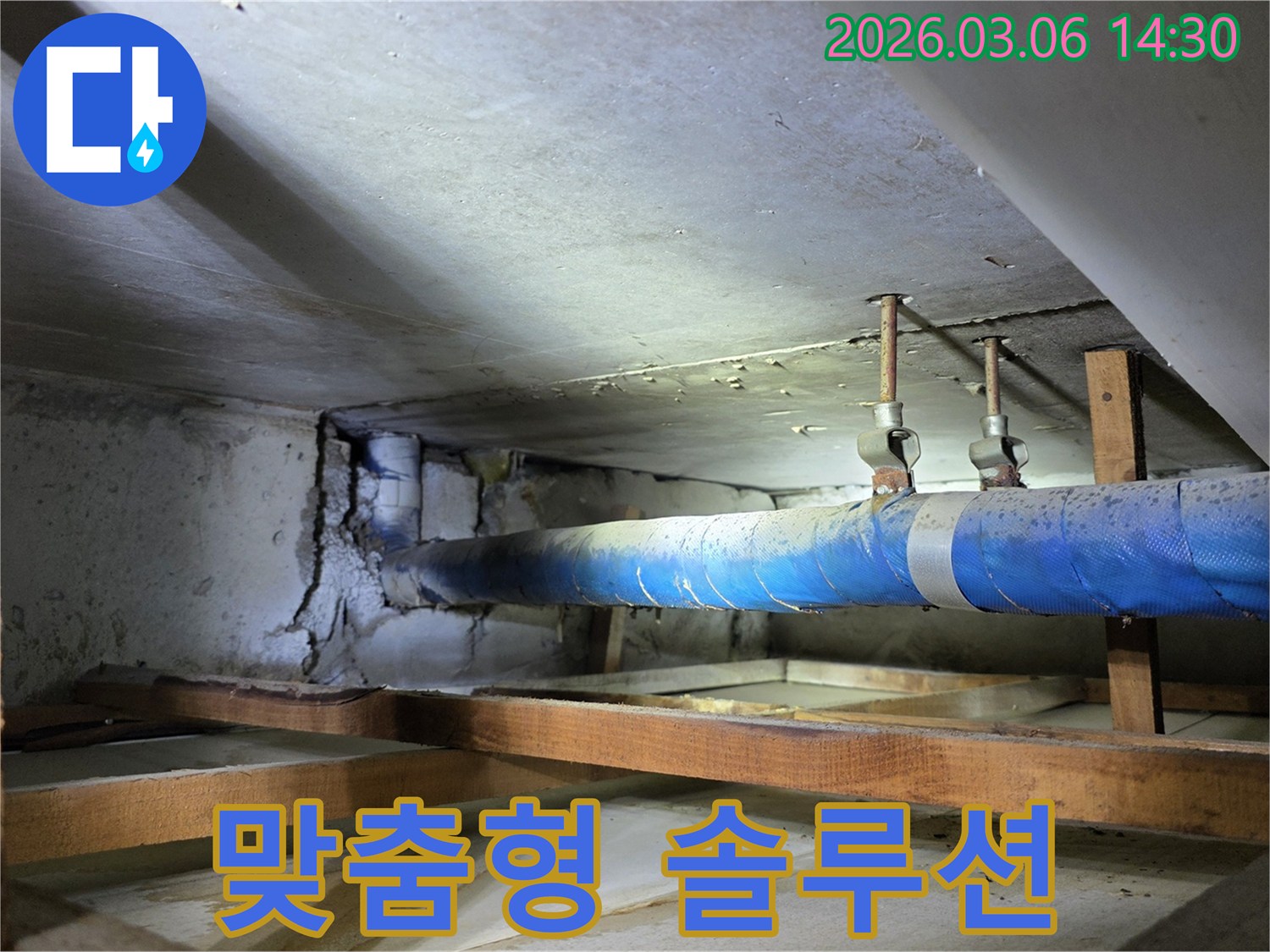 지하 공간의 파란색 배관과-손상된 콘크리트 벽면을-누수 엔지니어가-점검하며 맞춤형 솔루션을-제공하기 위한 방안을 모색하는 모습
