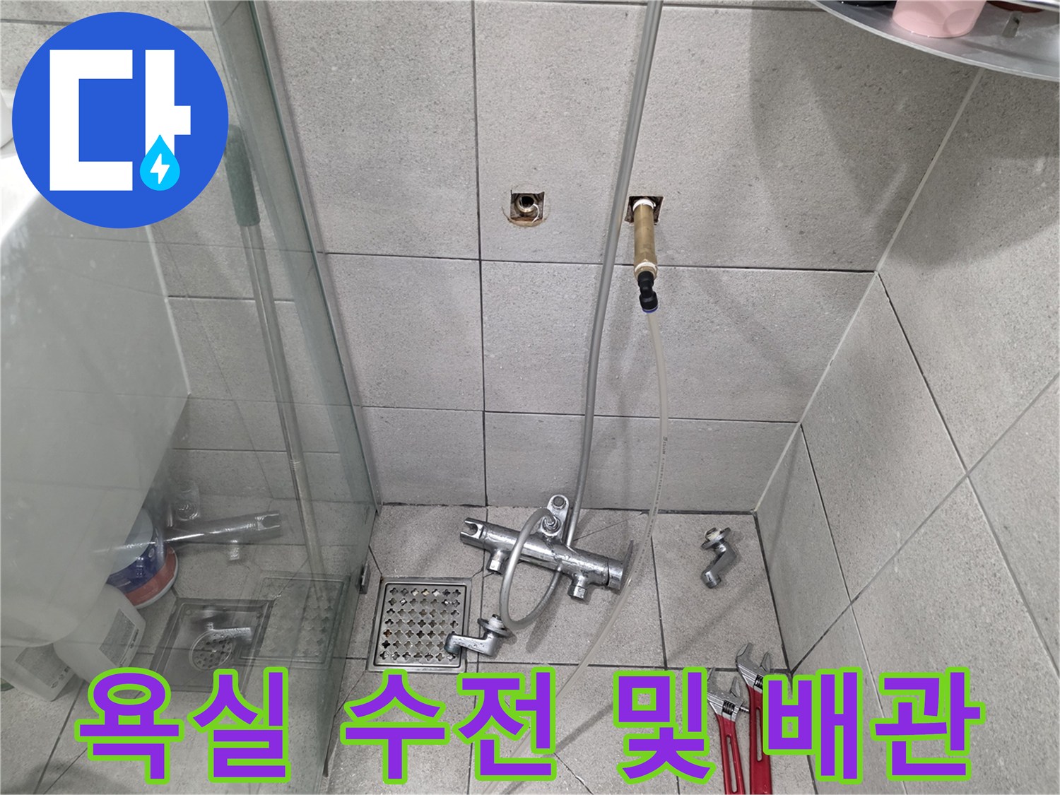 화장실 타일 벽면에 노출된-수도 배관과 몽키스패너