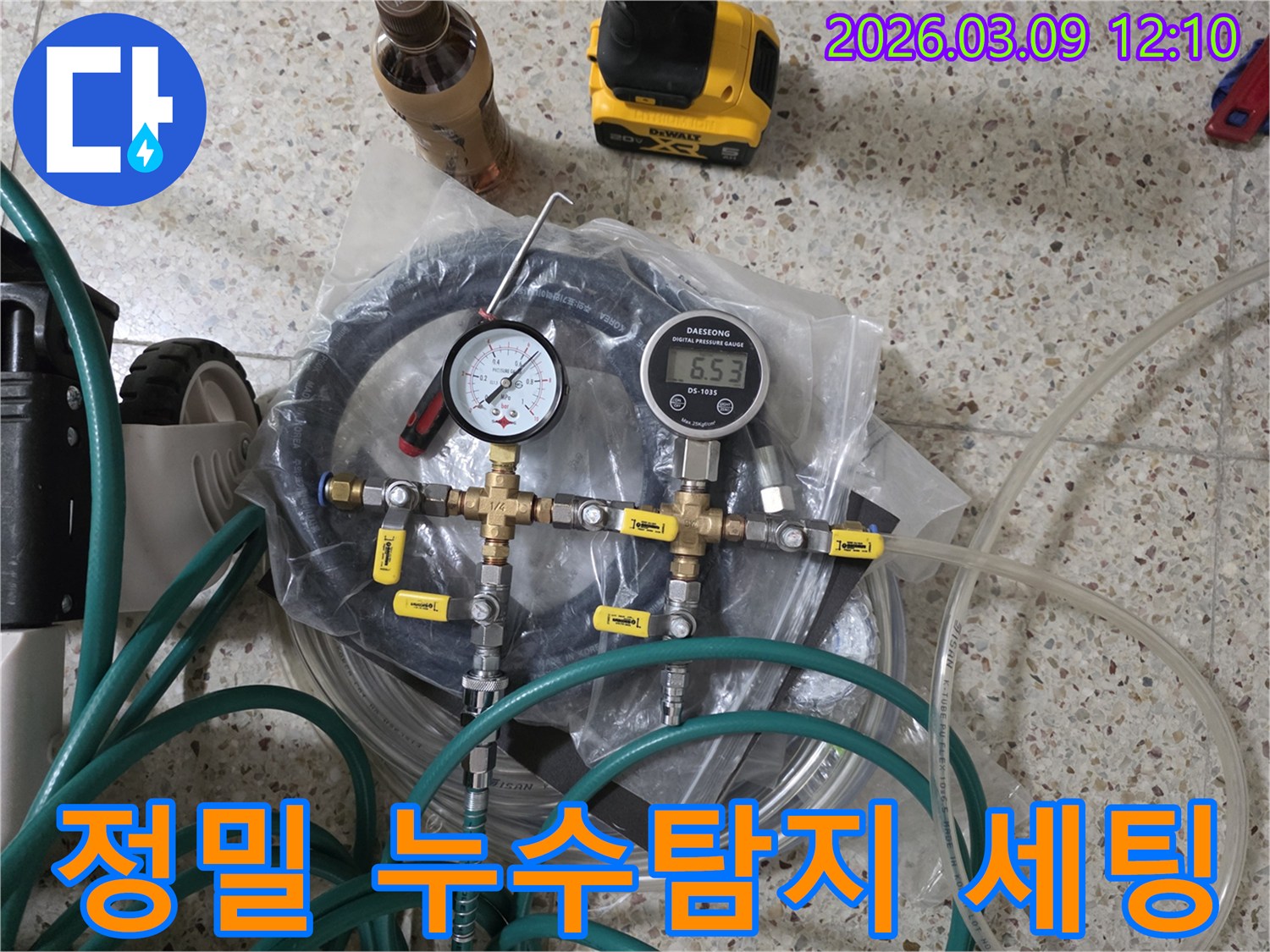 누수 공사를 위한 정밀한 누수탐지 장비들이-압력계-호스-밸브 등과 함께 바닥에 가지런히 놓여 있습니다.