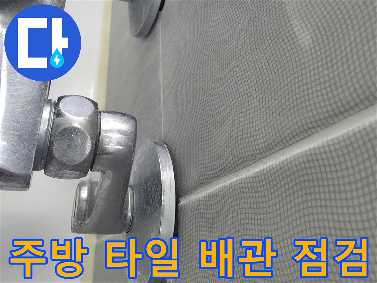 주방 타일 벽면과 수전 배관 연결 부위 근접 촬영