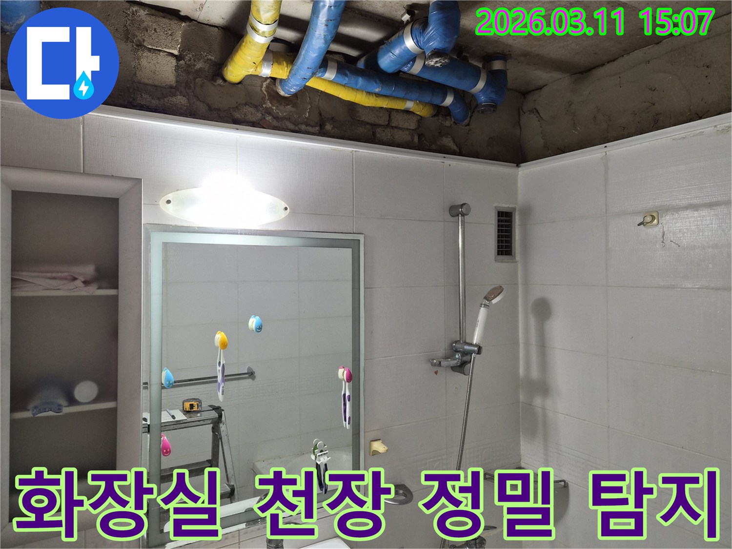 화장실 천장 내부의-파란색과 노란색 배관들이-정밀한 누수 탐지를 위해-노출된 모습