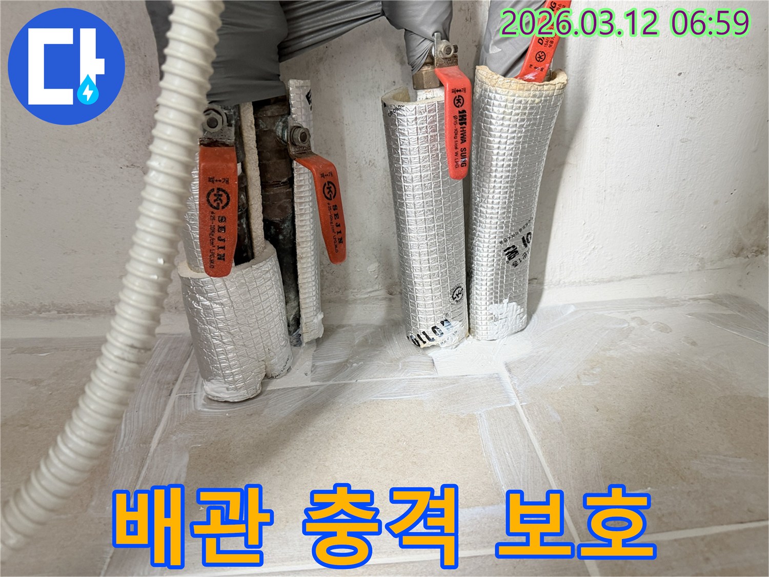 누수-공사-현장에서-배관-외부-충격-보호를-위해-보온재를-시공하는-모습