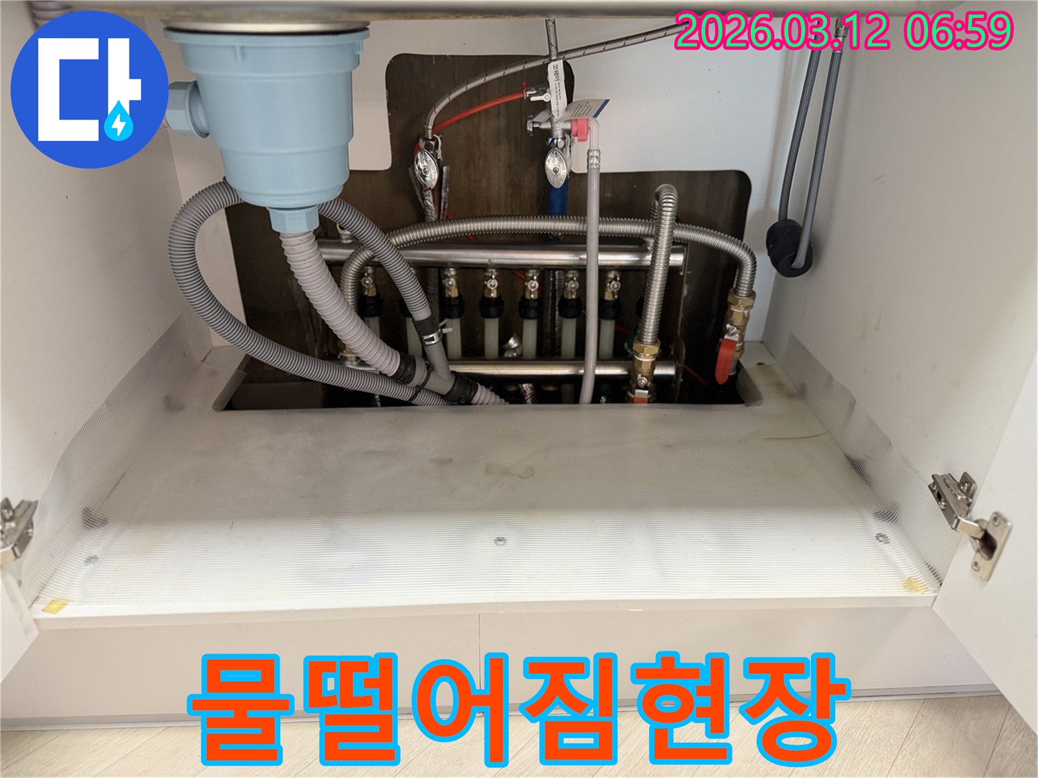 싱크대-밑에서-물이-떨어지는-현상을-해결하기-위해-마포구-누수-전문가가-배관을-점검하는-모습입니다.