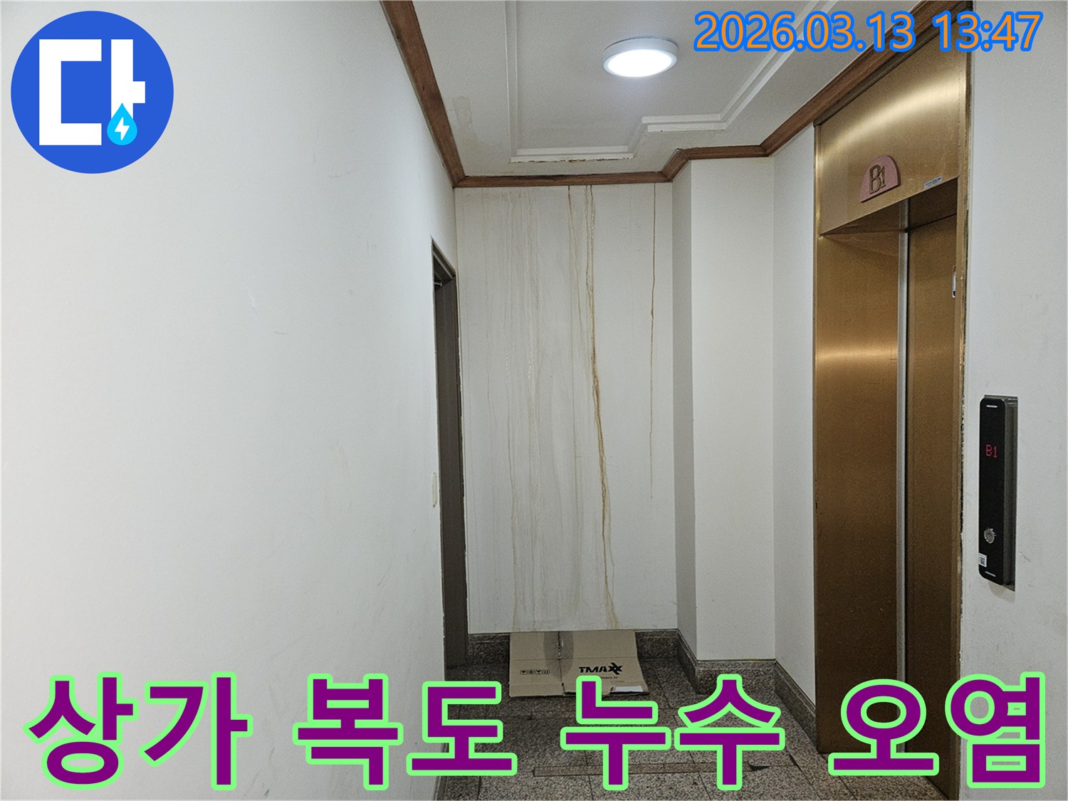 이 사진은 상가 복도 벽면에 발생한 누수로 인해-물이 흘러내려 심하게 오염된 모습을 보여줍니다-천장과 벽의 경계에서 누수가 시작된 것으로 보입니다