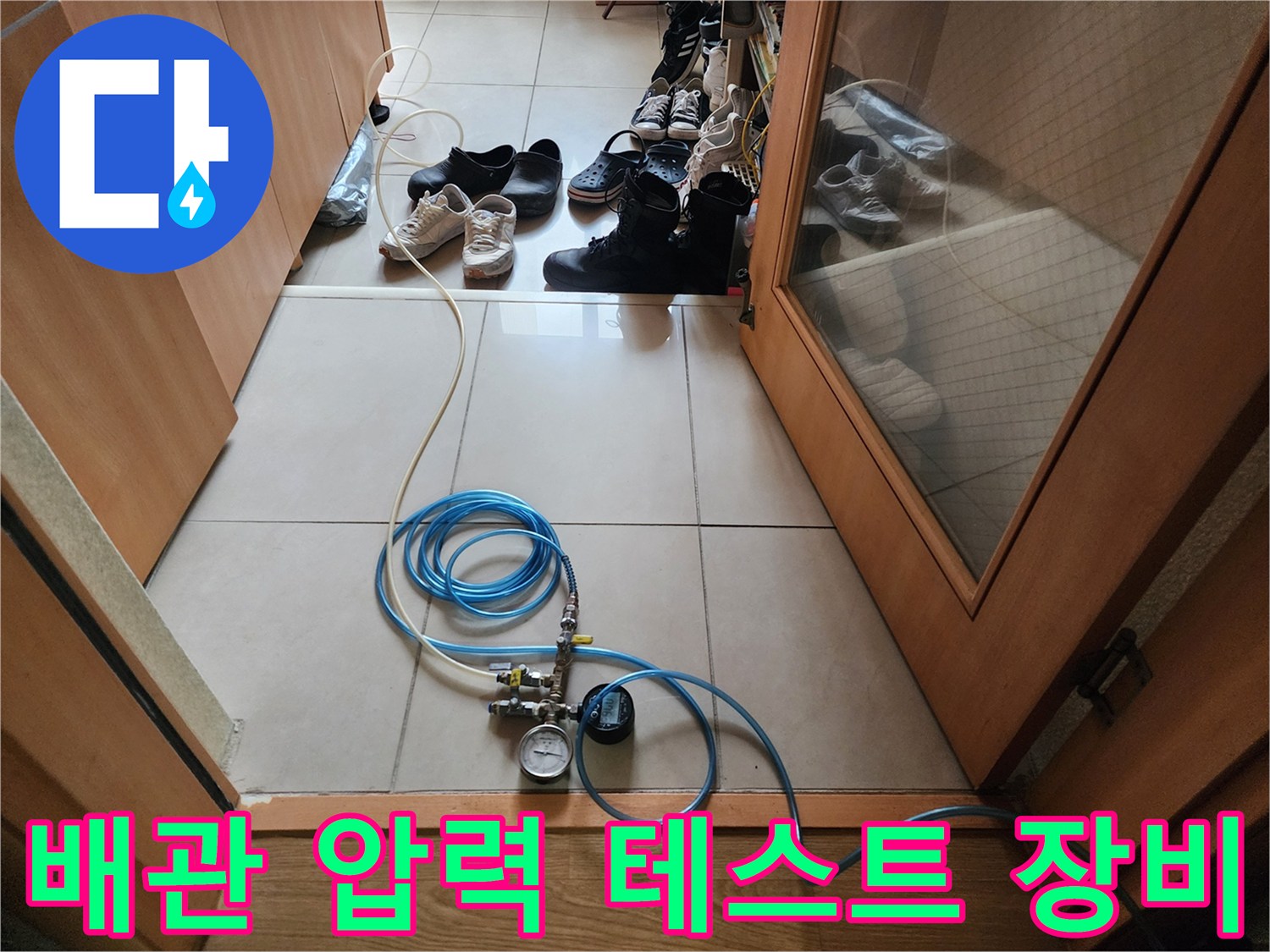 누수 진단을 위해 바닥에 설치된 공압 테스트 장비와 파란색 호스