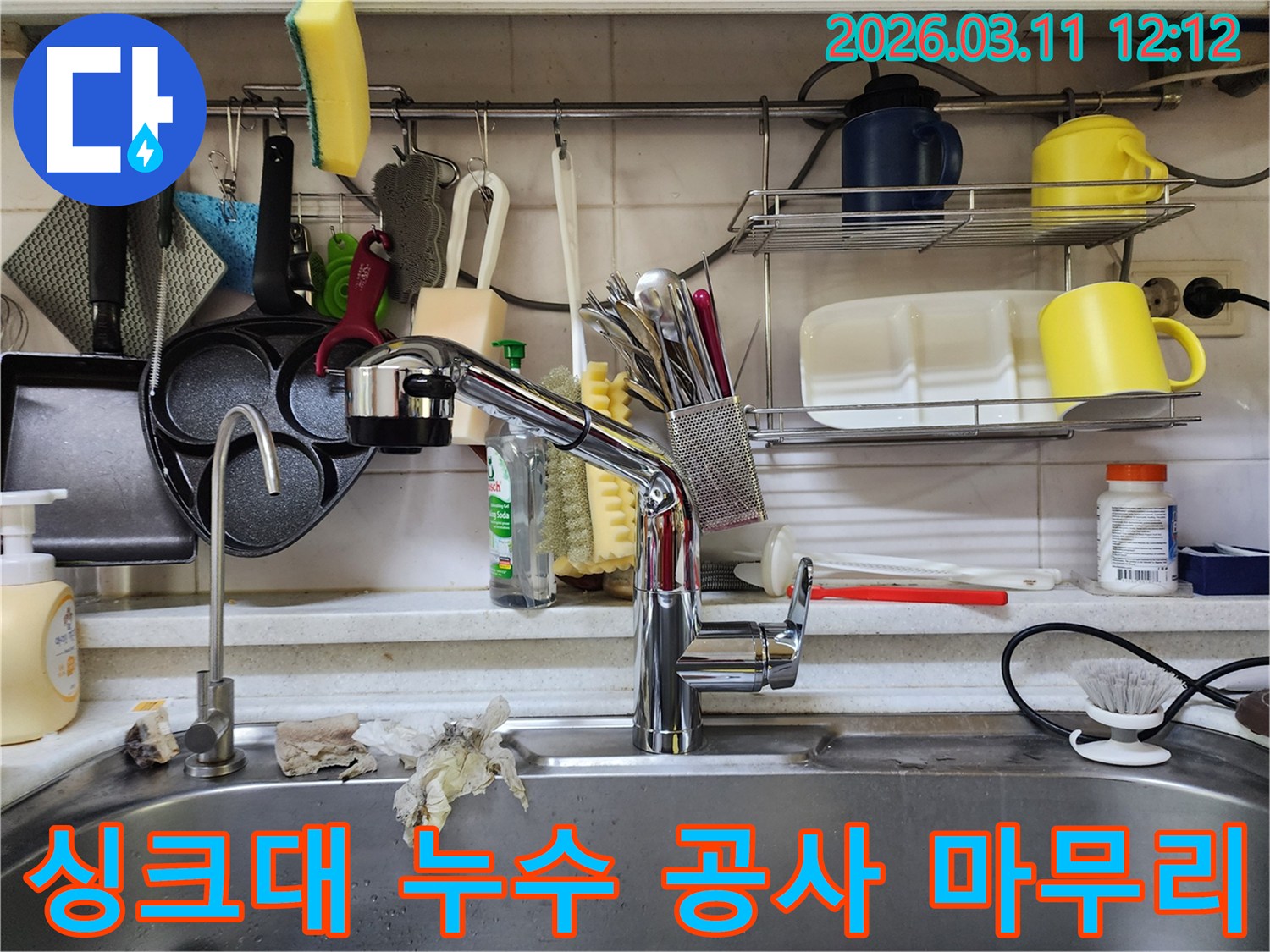 싱크대 누수 공사를-완료한 후-주변을 정리하고-최종 점검하는 모습