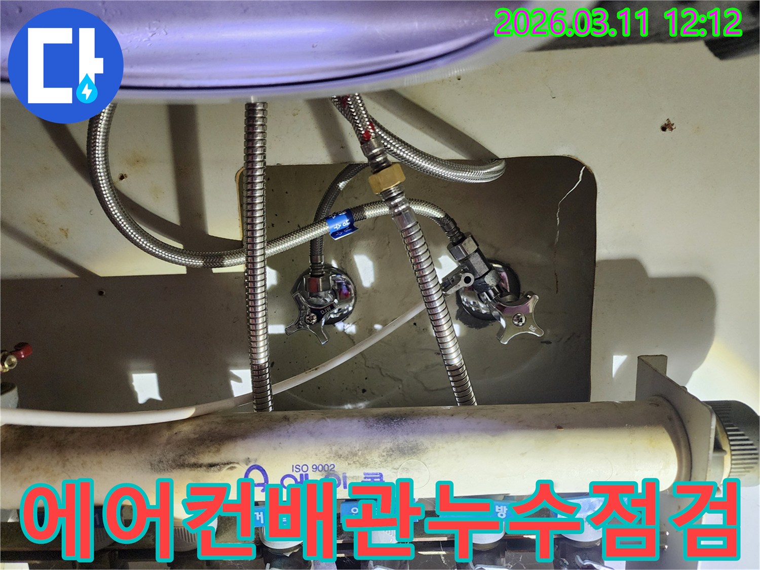 에어컨-배관과-연결된-싱크대-하부-수도-밸브-및-호스-연결-상태를-보여주는-사진