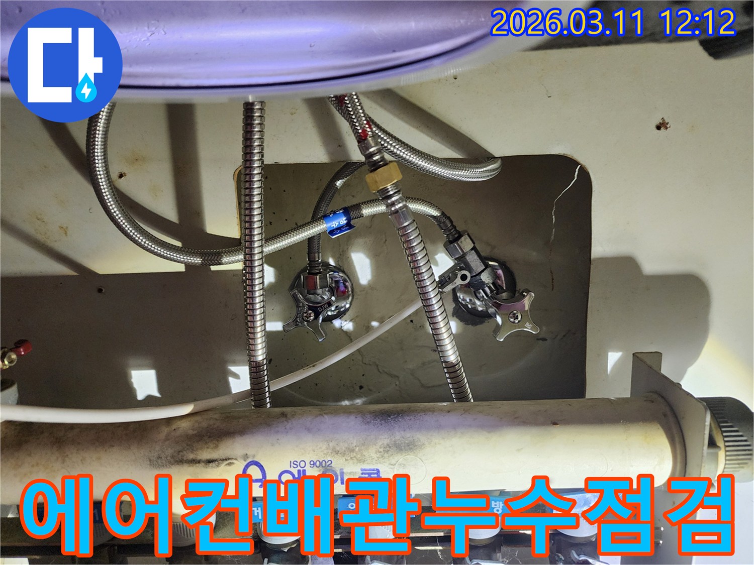 에어컨-배관과-연결된-싱크대-하부-수도-밸브-및-호스-연결-상태를-보여주는-사진