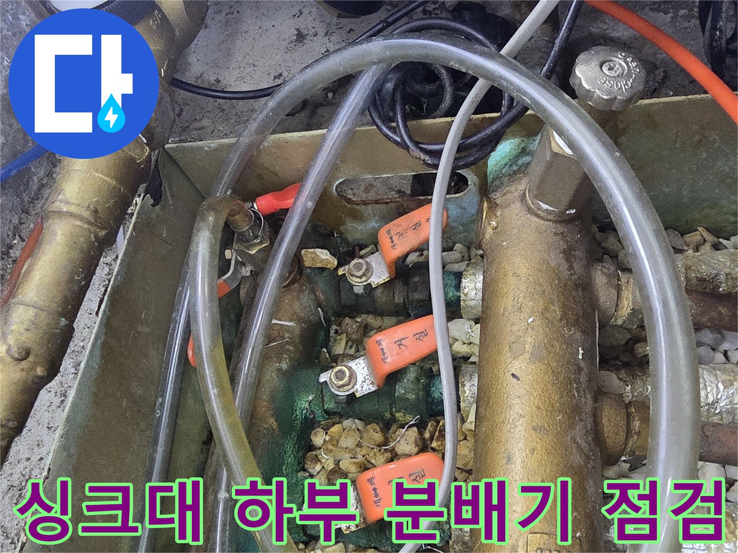 싱크대 아래 복잡하게 얽힌 분배기 밸브와 호스 사진