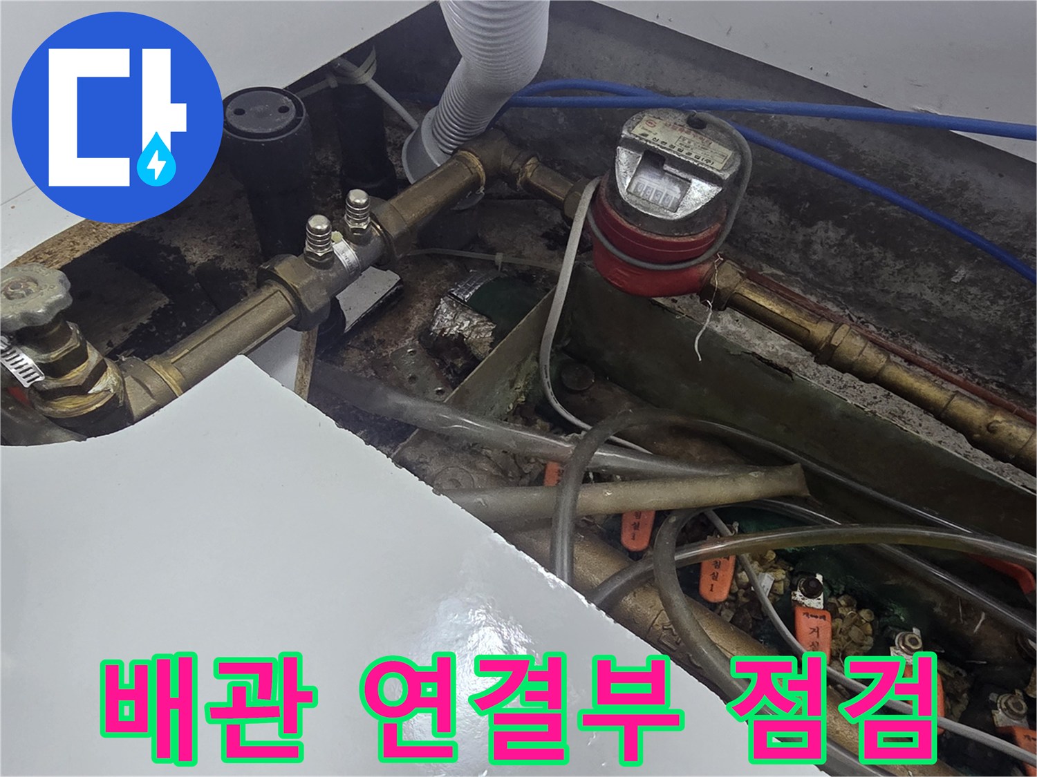 싱크대 하부의 금속 배관과 수전 연결 호스의 상태를 보여주는 사진입니다.