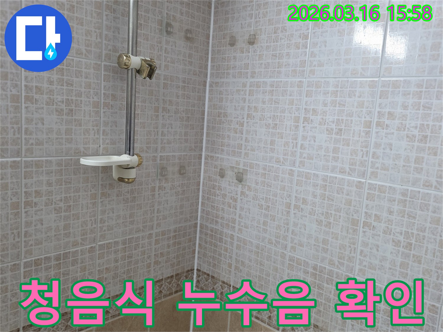 욕실 천장 타일에 물이 새어 생긴-얼룩 주변에서 청음식 탐지기로-미세 누수음을 확인하는 누수 전문가의 모습