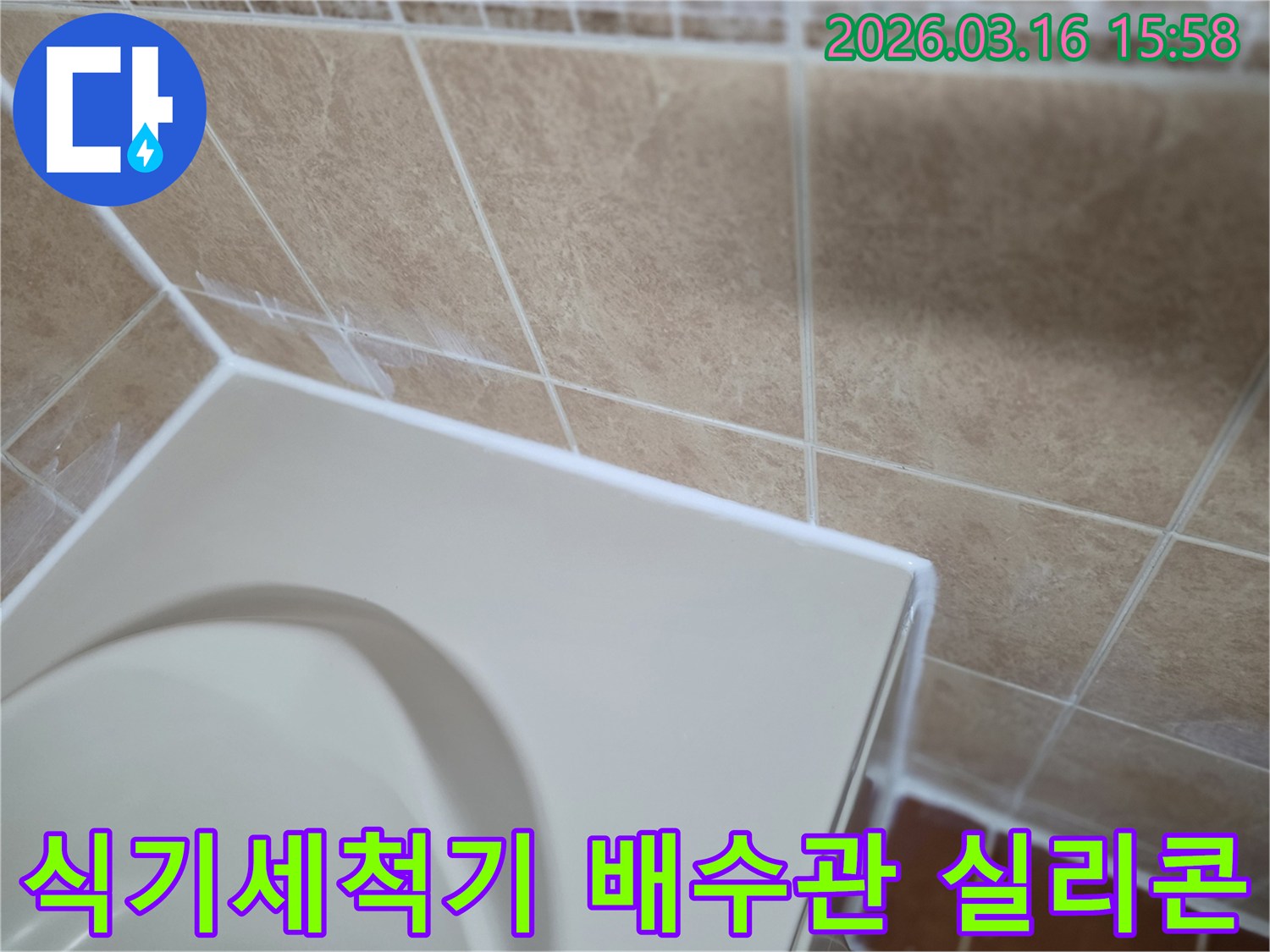 이-이미지는-식기세척기-배수관-연결부를-고품질-방수-실리콘으로-깔끔하게-마감하여-누수를-완벽하게-차단하는-시공-과정을-보여줍니다.