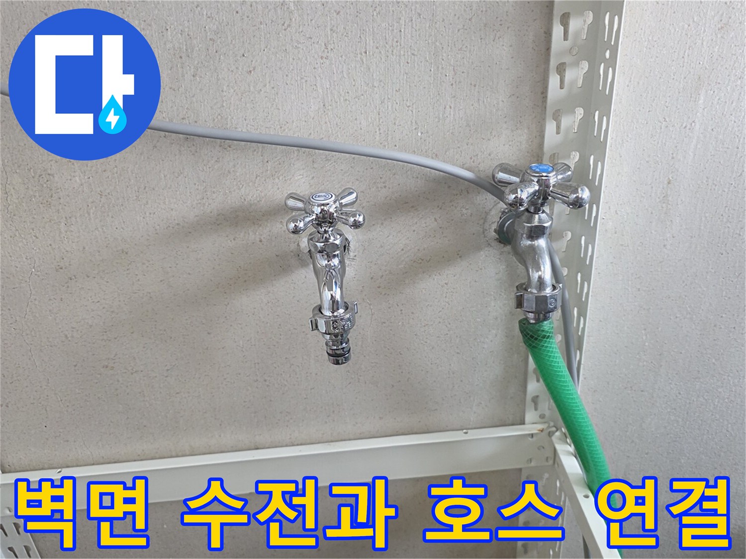벽면에 고정된 수전-초록색 호스가 연결되어 있음