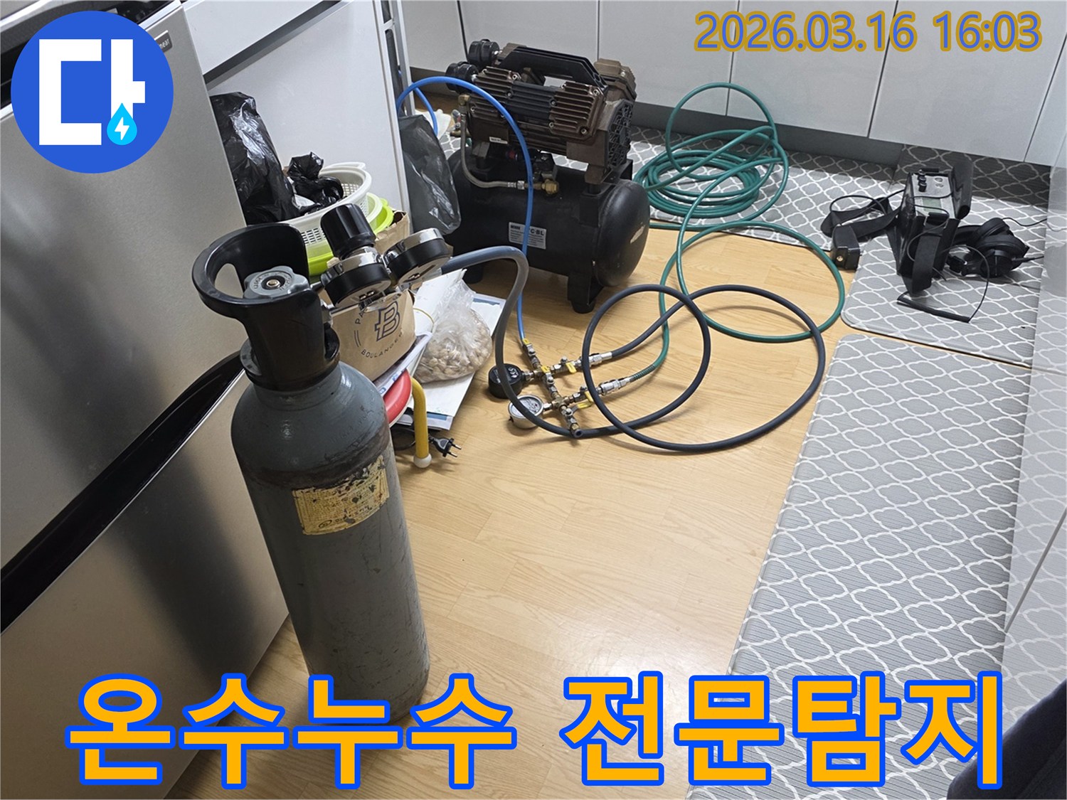 온수관 누수 원인을 정확히 찾아내기 위해-질소 가스통과 압축기를 연결하여-정밀 탐지를 준비하는 현장입니다
