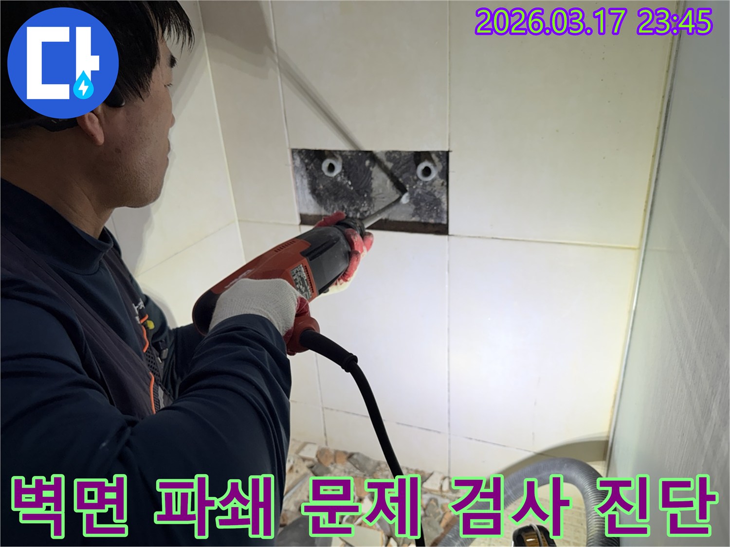 누수 전문가가 벽면 타일을 깨끗하게 파쇄하며-누수 원인인 배관의 문제점을 육안으로 검사하고 진단하는 작업을 진행 중입니다.