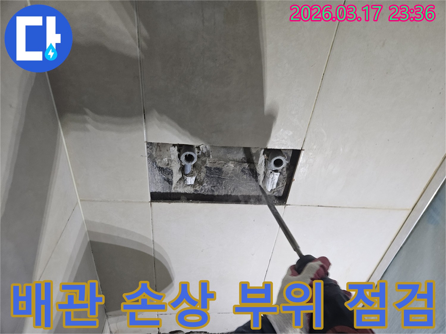 누수 해결을 위한-필수 단계로-벽면 타일 파쇄 후-배관을 노출하여-손상 부위를-집중 점검하는 모습입니다
