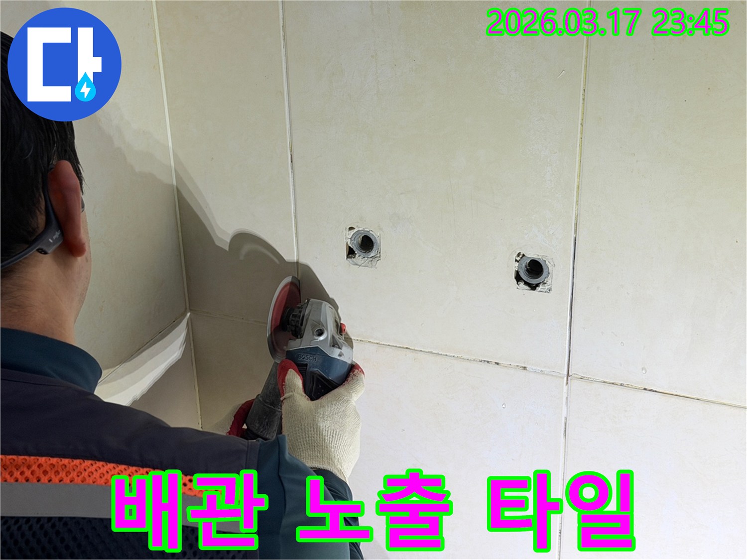 누수된 배관을-노출시키기 위해-전문가가-타일 벽면을-그라인더로-조심스럽게-제거하고-있습니다
