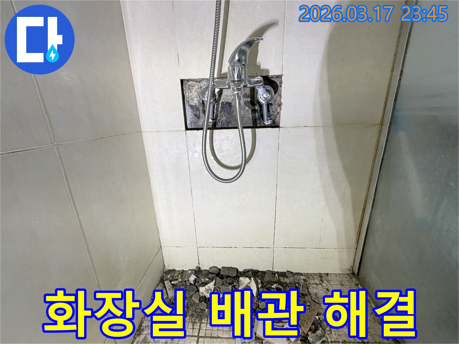 병점 아파트 화장실 누수 현장에서-배관 문제 정밀 진단 및 해결을 위해-샤워 수전이 제거되고-바닥 타일이 파손된 채로-공사가 진행 중인 모습입니다.