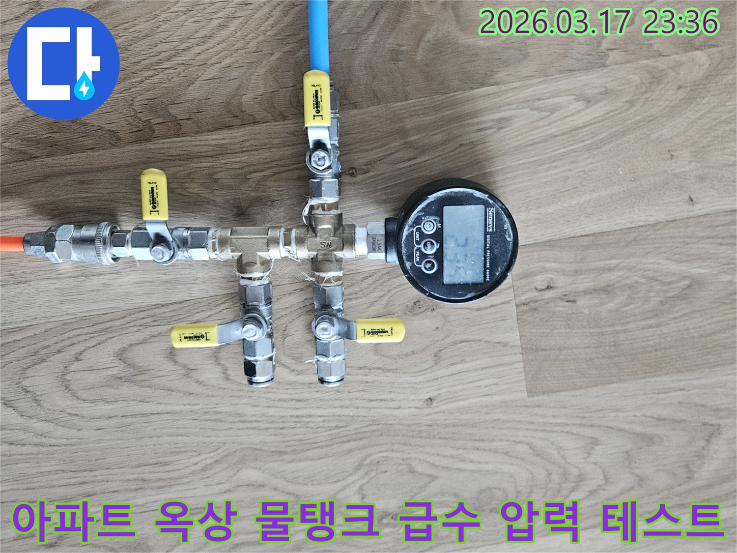 아파트 옥상 물탱크 급수 배관의 누수 여부를 확인하기 위해-전문 압력 테스트 장비를 연결하여-정밀하게 검사하고 있습니다.