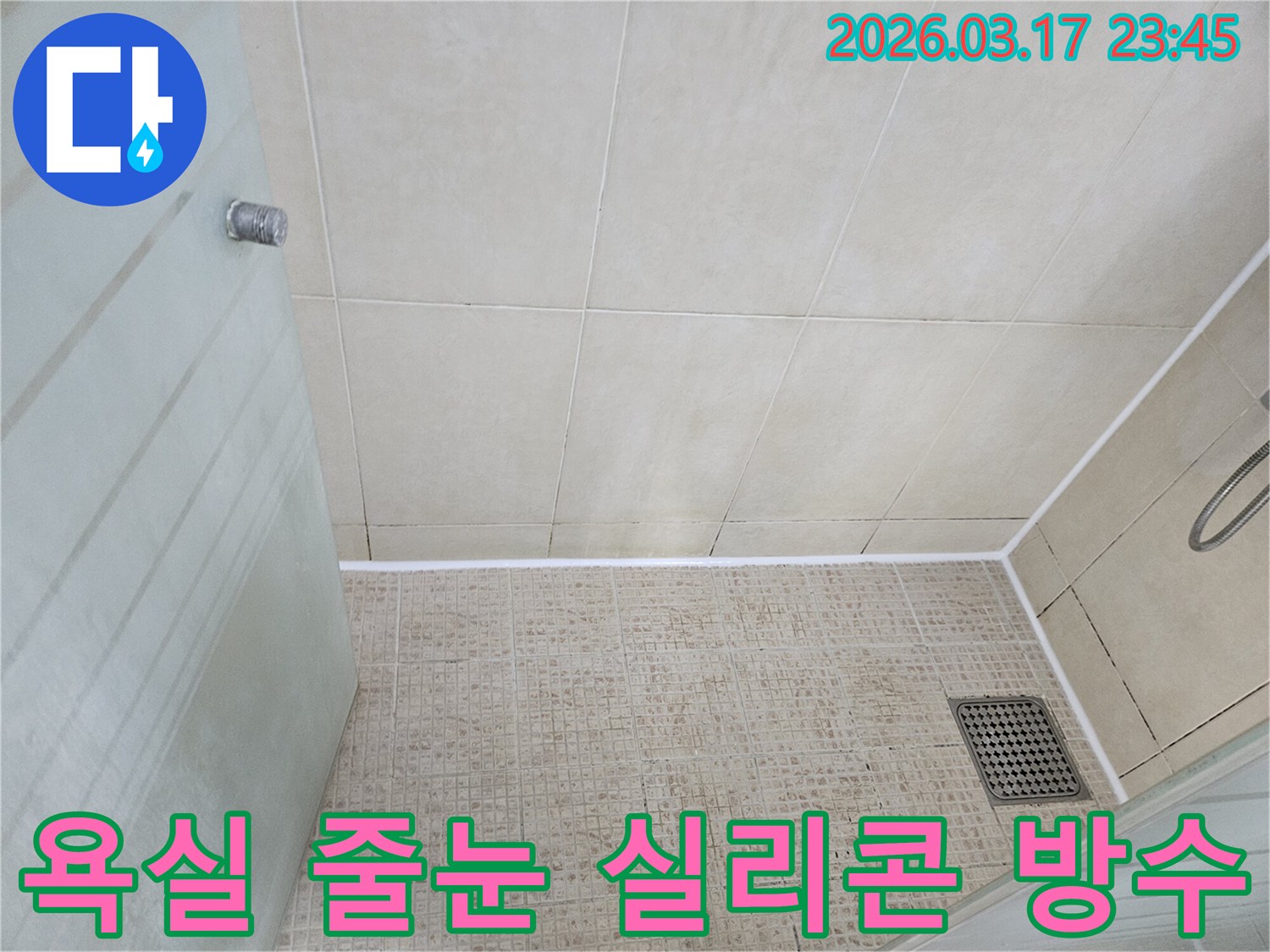 오래된 욕실 타일의 줄눈 부분과-벽면 경계에 새롭게 시공된-하얀색 실리콘이 깔끔하게 마감된 상태를 보여줍니다