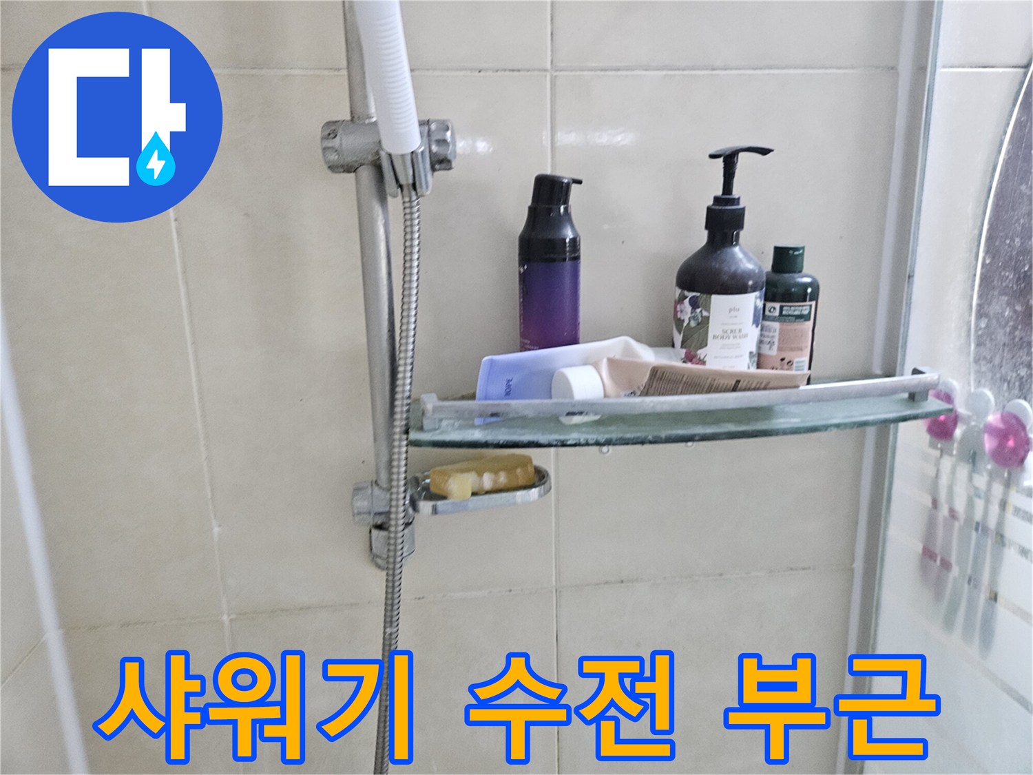 욕실 선반과 샤워기 수전이 위치한 타일 벽면 사진입니다.