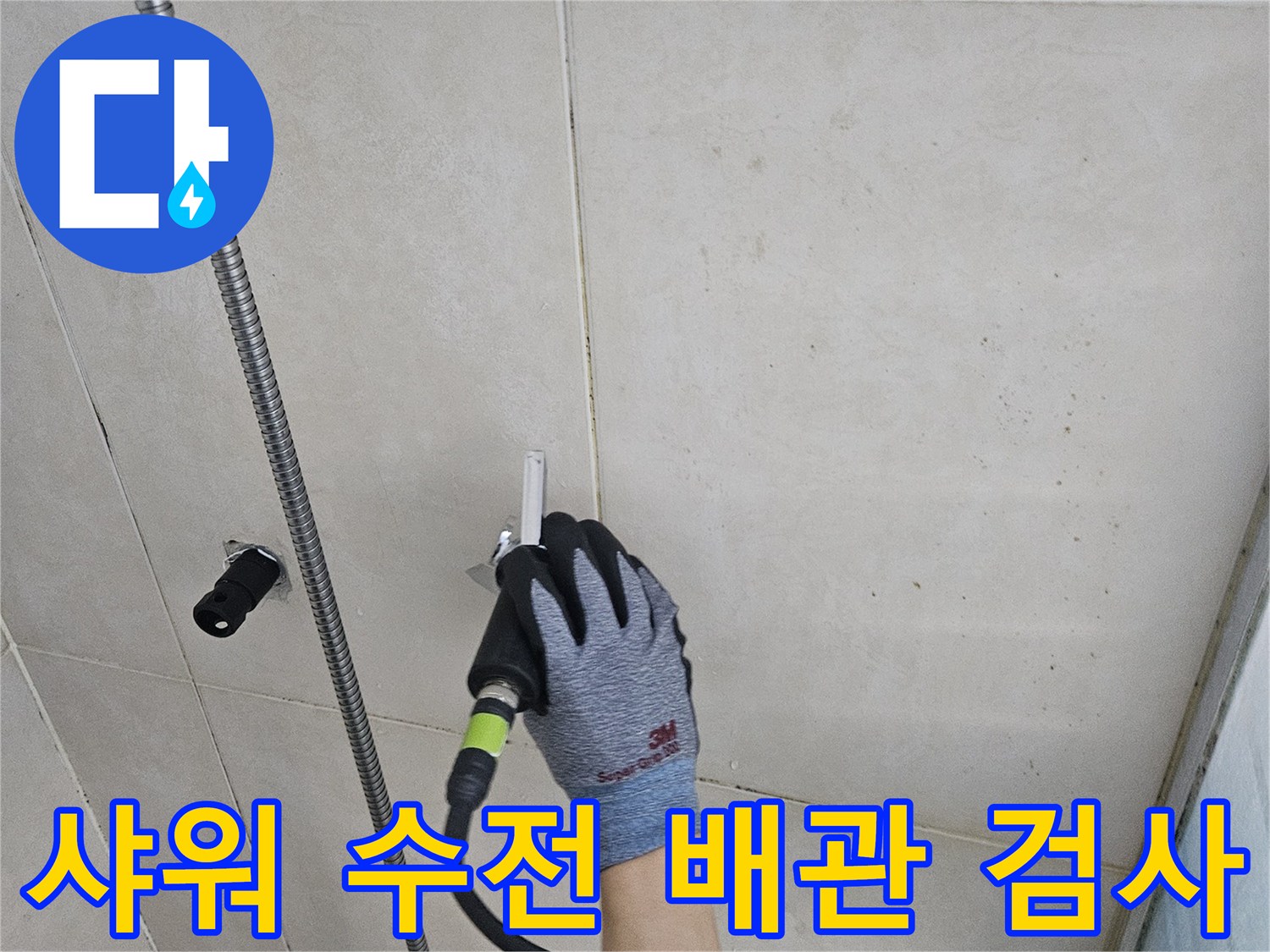 작업자가 샤워기 수전 배관에 압력 측정 장치를 연결하여 점검하는 모습