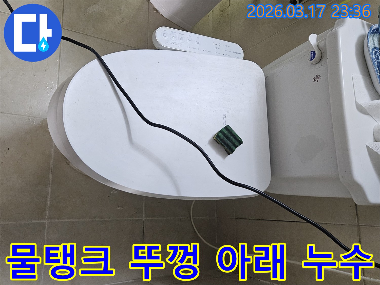 화성 병점동의 한 화장실에서 변기 물탱크 뚜껑 아래 미세 누수 현상을 점검하기 위해-전문 탐지 장비를 설치하고 있는 모습입니다