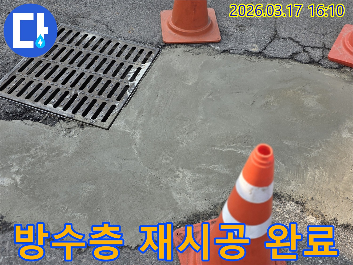 이 이미지는 양주 지역의 배수구 주변 누수 방수층 재시공이 완료된 상태를 보여주며-새로운 시멘트 마감과 안전 콘이 놓여 있습니다.