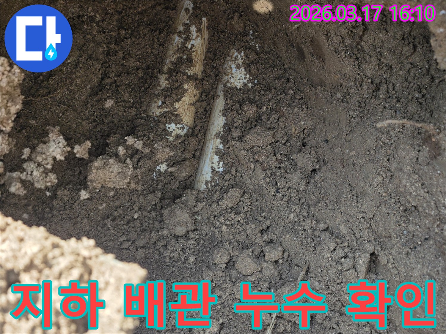 지하에 묻힌-수도배관에서-누수가 발생하여-주변 흙이 젖어있는-상황을 보여줍니다