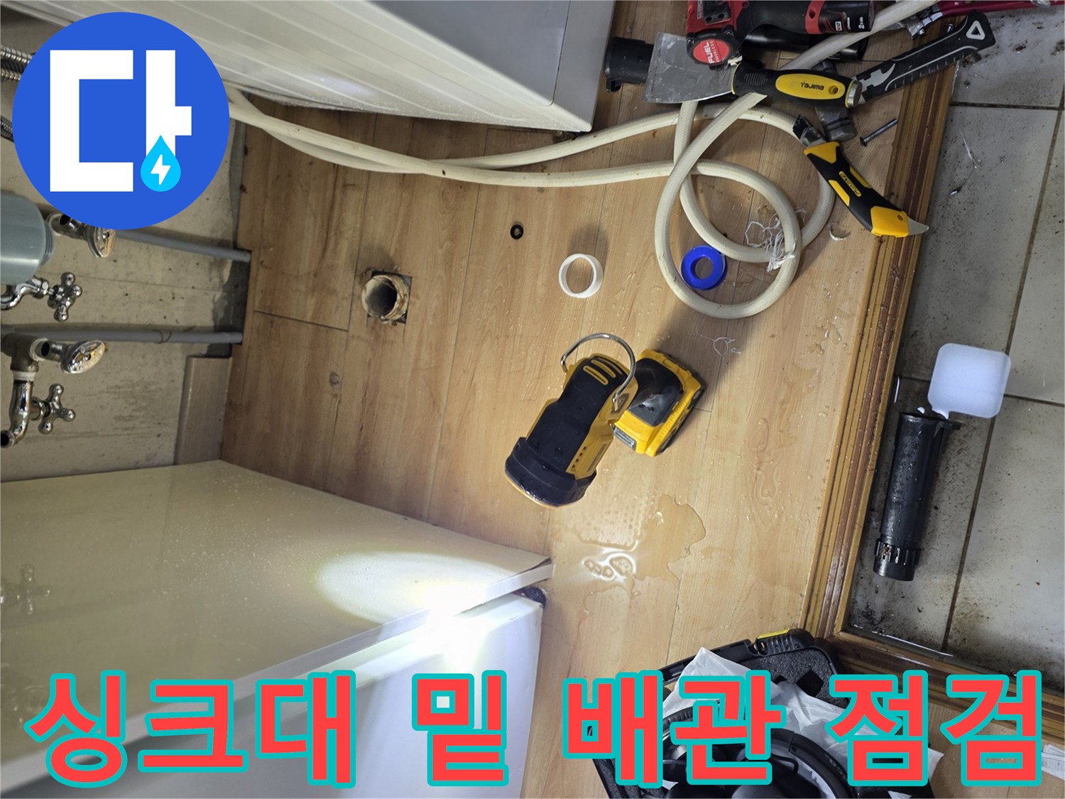 세탁기와 싱크대 사이 좁은 틈새에서 진행되는 누수 진단 작업