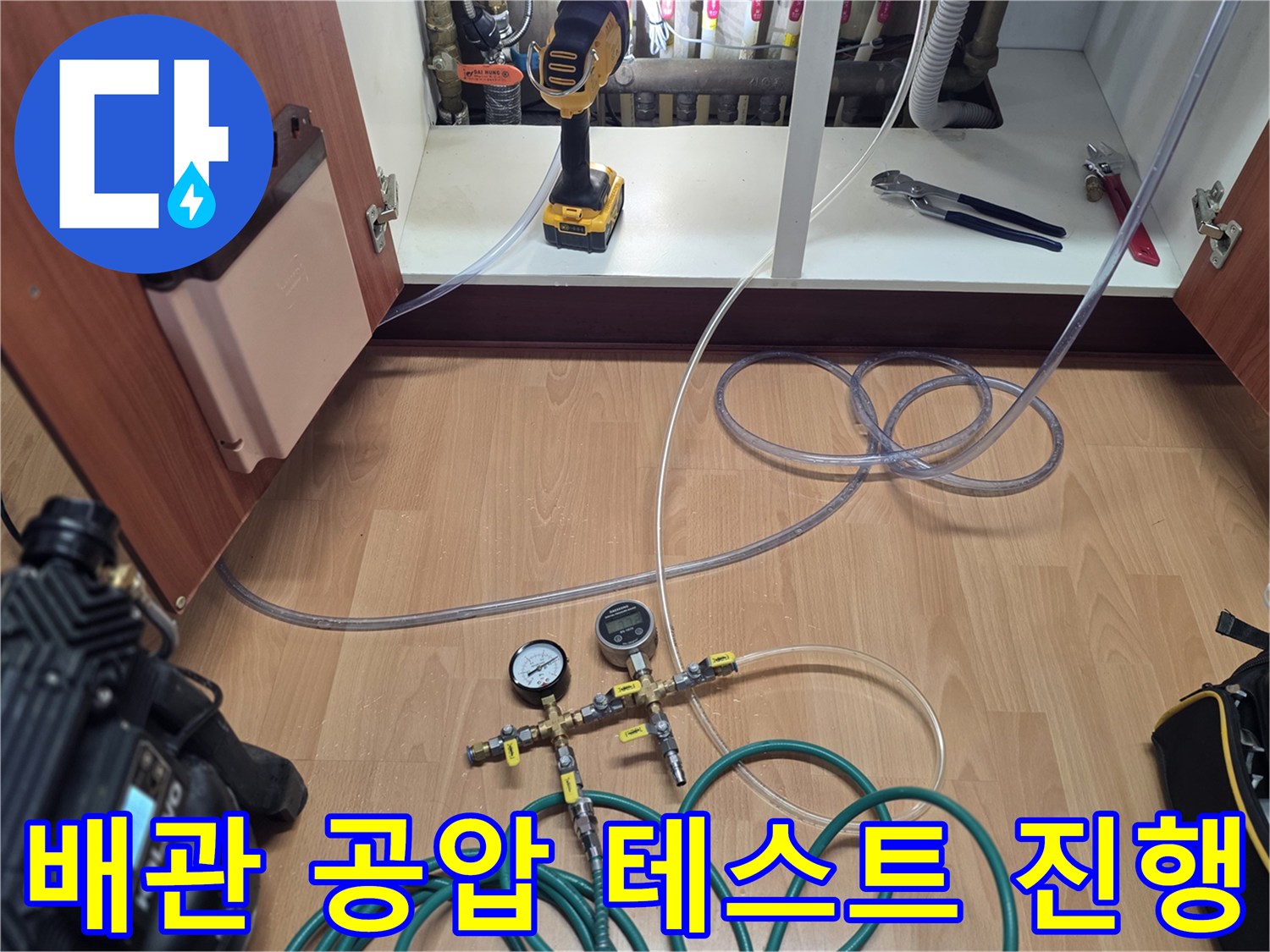 싱크대 하부장 내 배관에 연결된 압력 측정 게이지와 호스