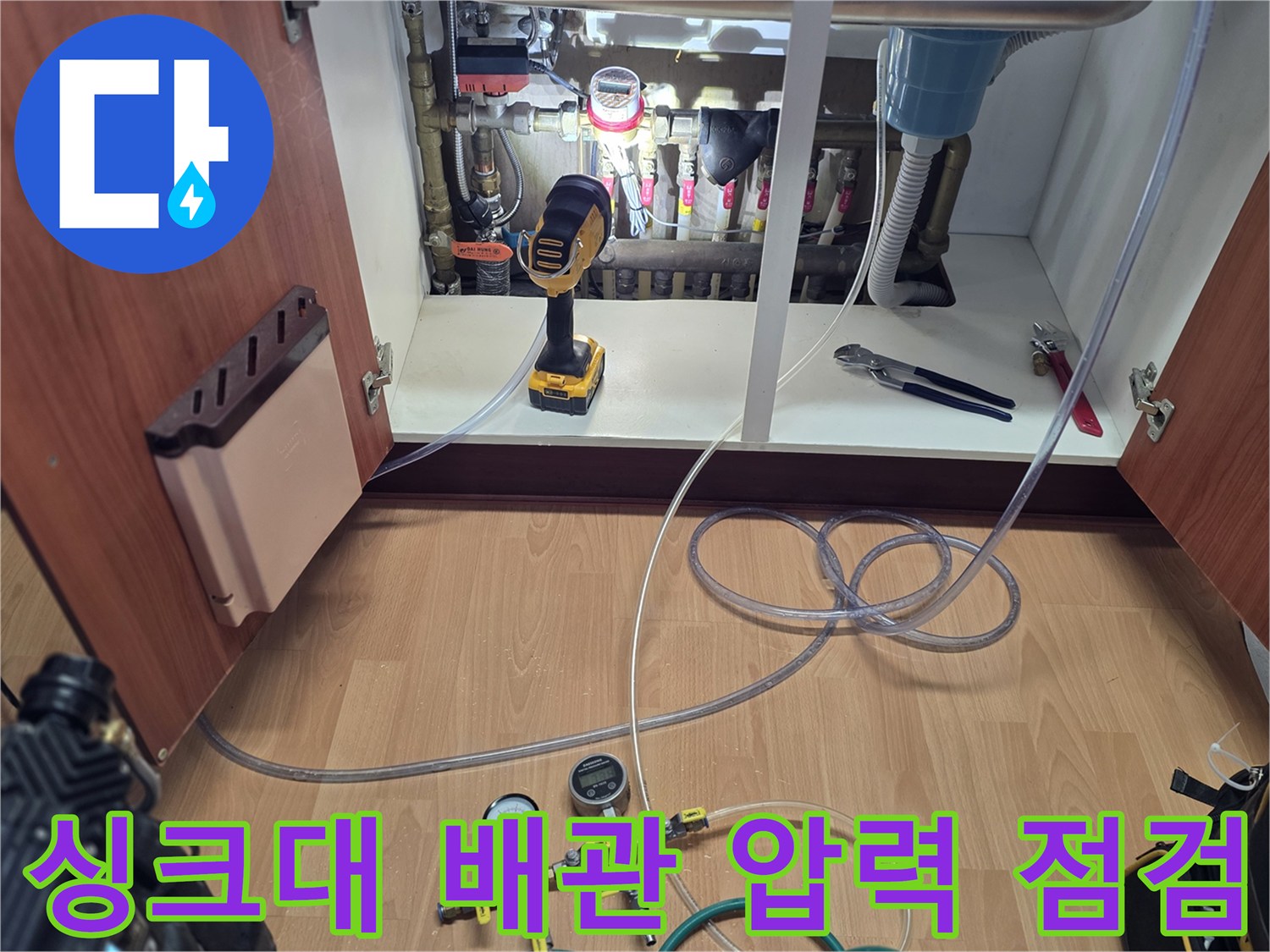 싱크대 하부장 분배기에 연결된 압력계와 호스 뭉치